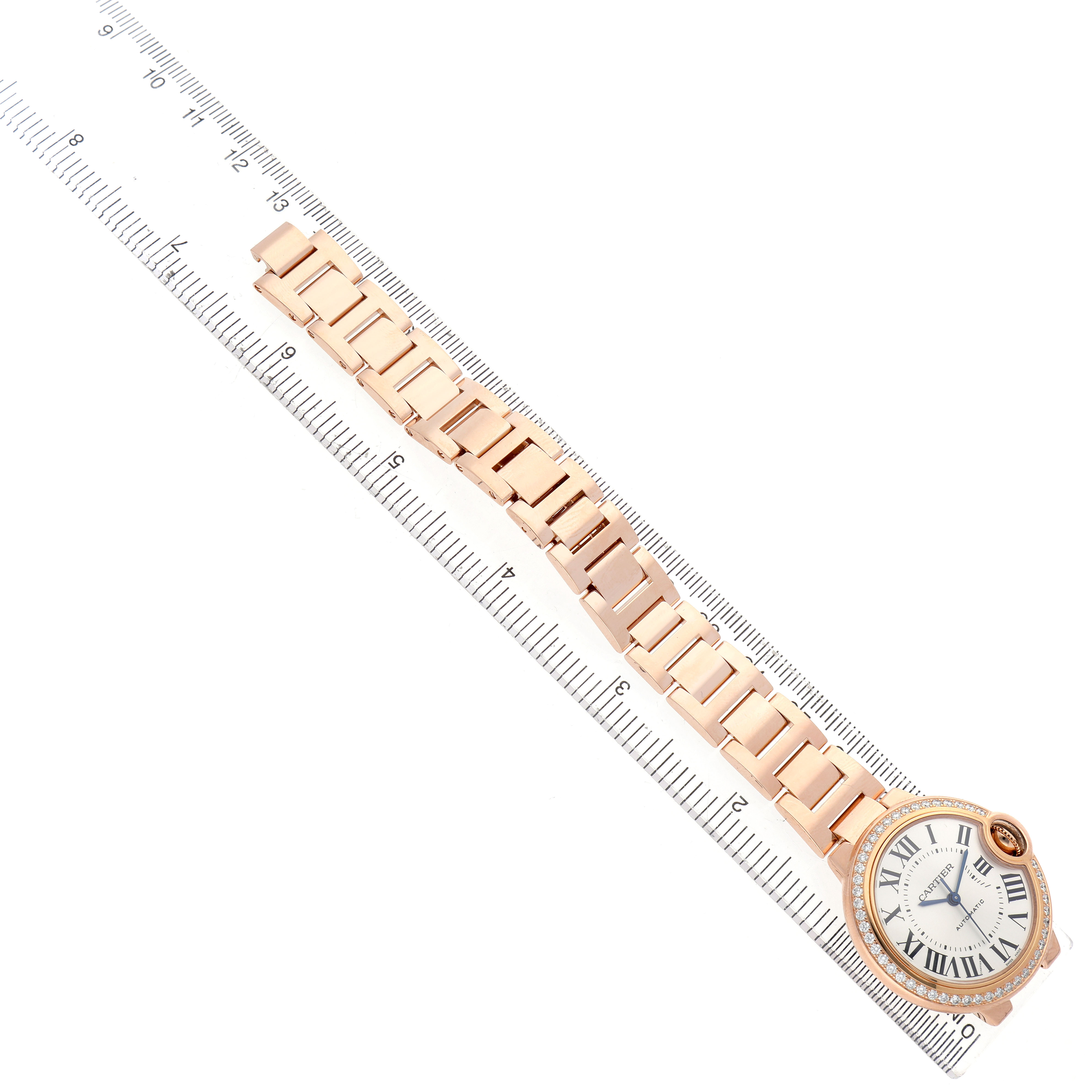 The Cartier Ballon Bleu WJBB0036 Women's Rose Gold Silver Dial watch is shown from a top-down angle, displaying the entire bracelet and dial alongside a ruler for scale.