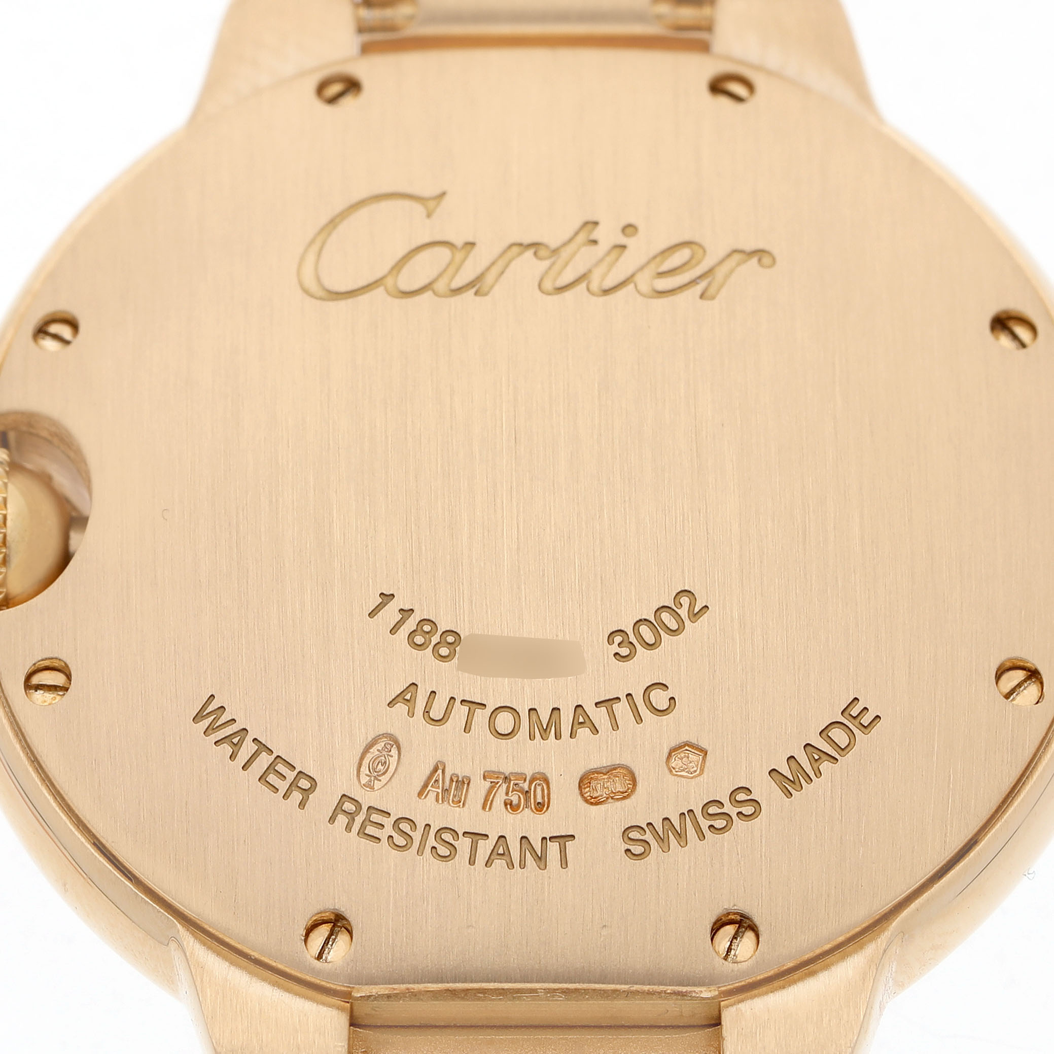 The image shows the back case of a Cartier Ballon Bleu WE9004Z3 Women's Yellow Gold Silver Dial watch, highlighting the brand name, model details, and material specifications.