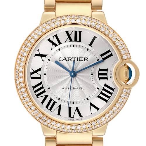 The Cartier Ballon Bleu WE9004Z3 Women's Yellow Gold Silver Dial watch is shown from the front, highlighting its round face, Roman numerals, diamond bezel, and metal bracelet.