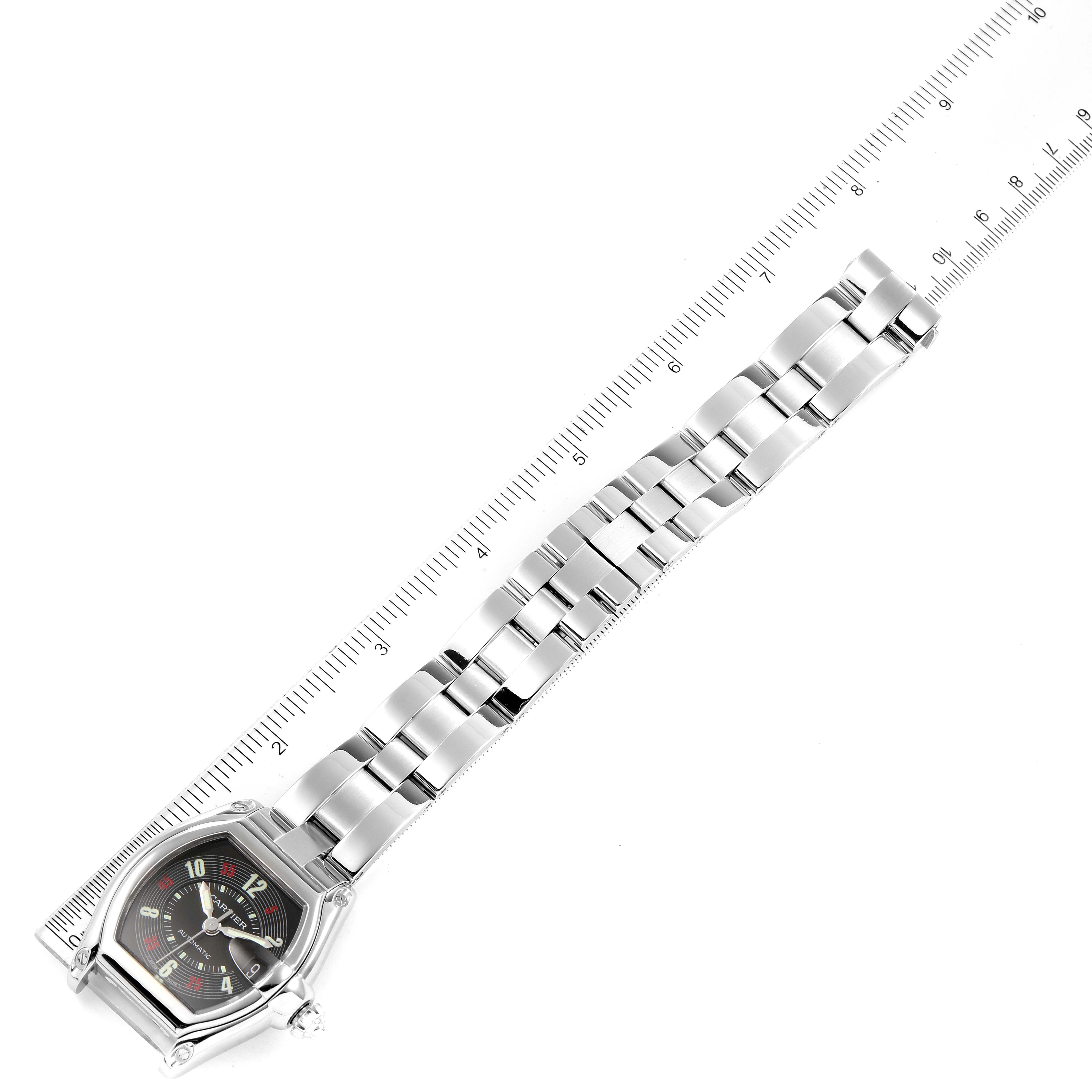 The image shows the Cartier Roadster W62002V3 Men
s Stainless Steel Black Dial W62002V3 Men
s Stainless Steel Black Dial watch laid flat, with the bracelet and face in full view, aligned with a ruler.