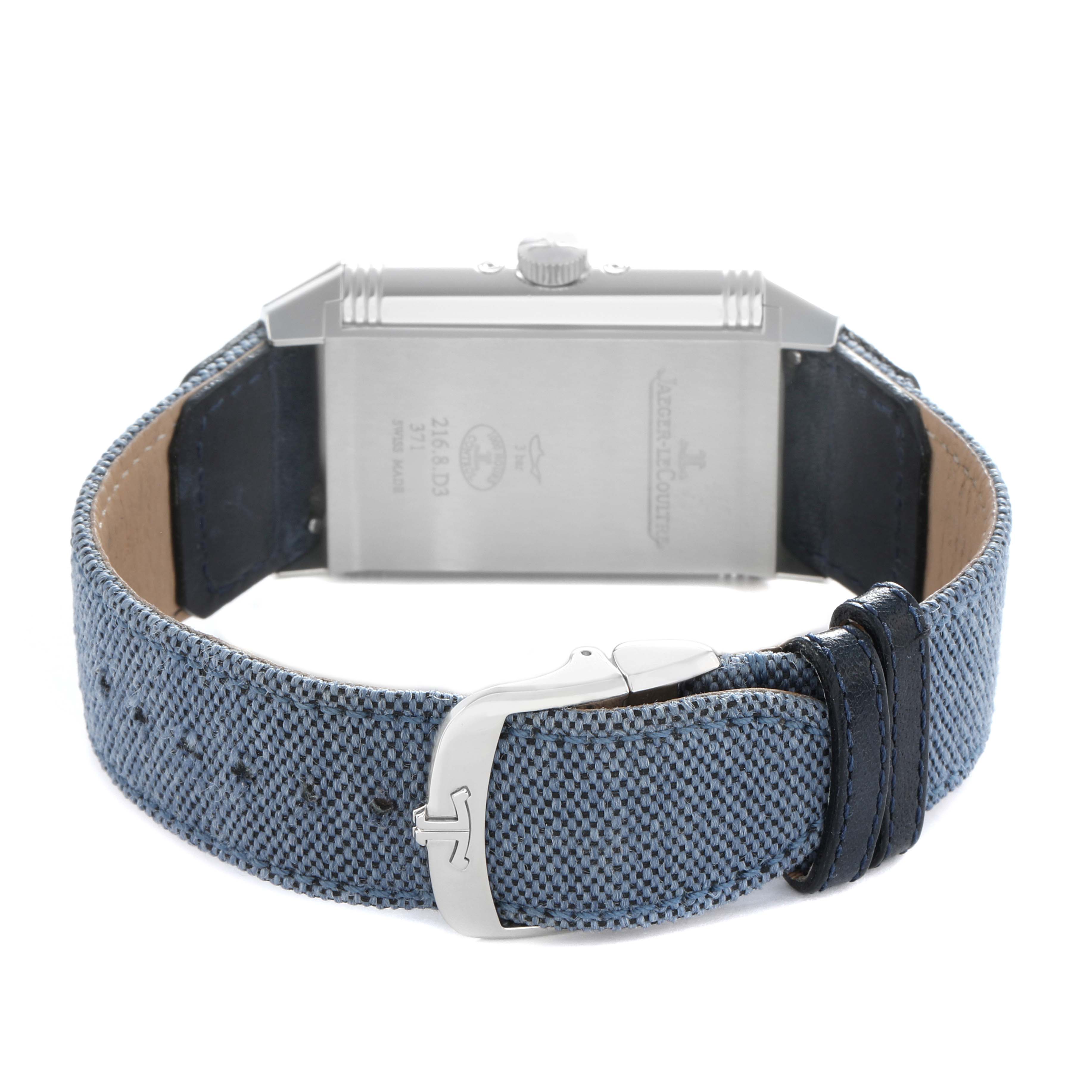 The image shows the back of a Jaeger-LeCoultre Reverso watch, focusing on the case back, crown, buckle, and blue strap.