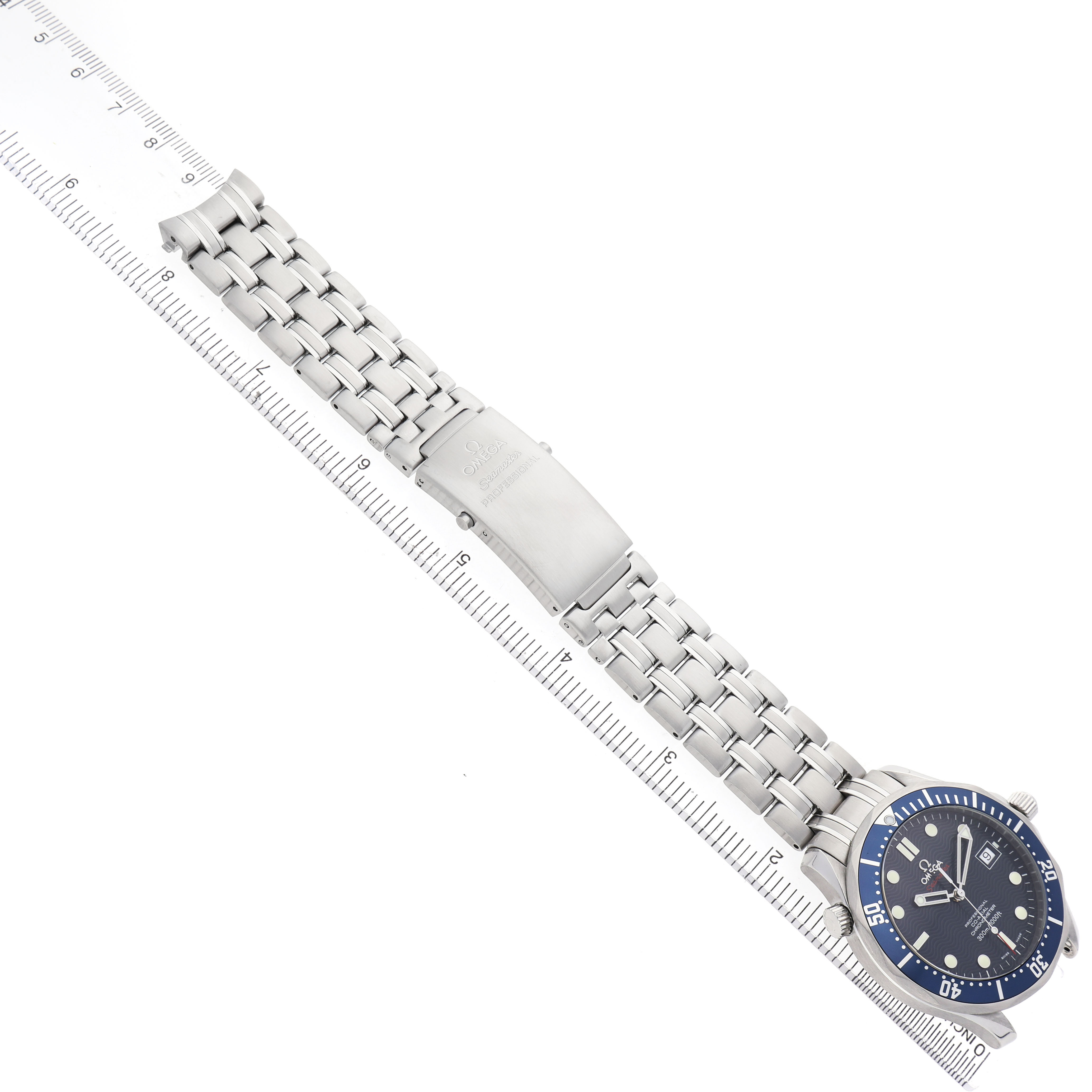 The Omega Seamaster 2220.80.00 Men's Stainless Steel Blue Dial watch is shown from a top-down angle, displaying the face and metal bracelet alongside a ruler.