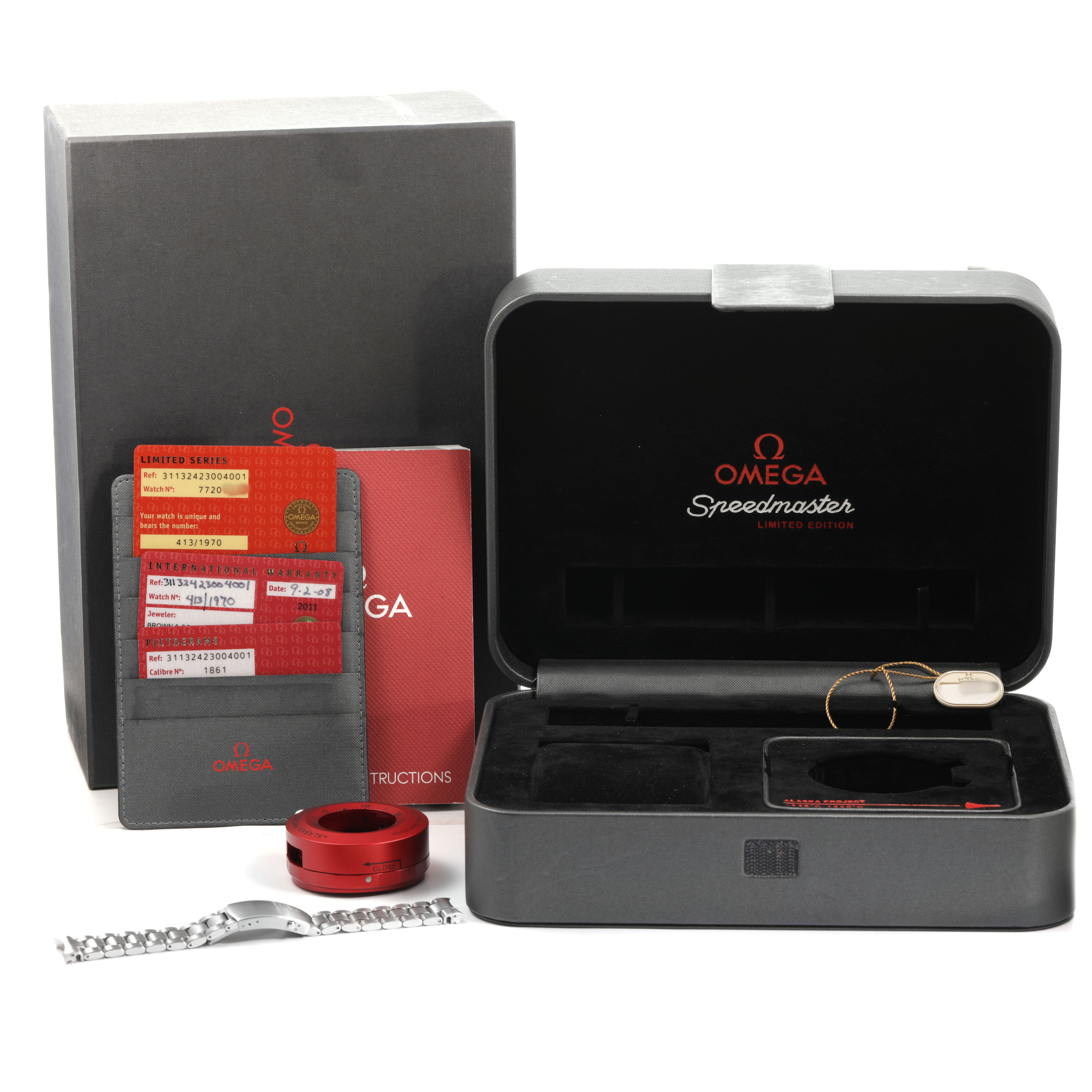 The image shows the Omega Speedmaster 311.32.42.30.04.001 Men's Stainless Steel White Dial watch box, accessories, cards, manual, bracelet, and case opener from a front angle.