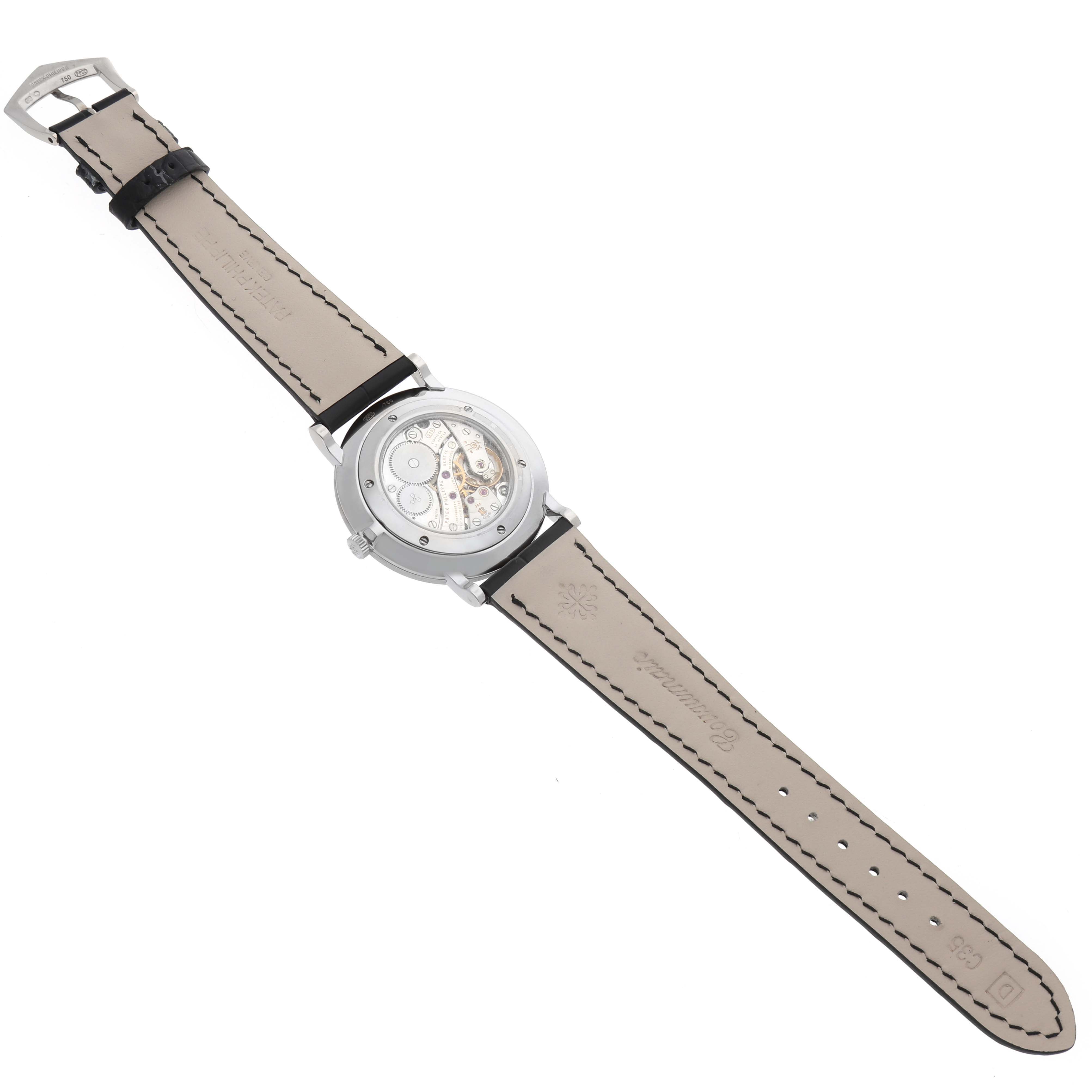 The image shows the back view of a Patek Philippe Calatrava 5119G Men
s White Gold White Dial watch, highlighting its movement and leather strap.