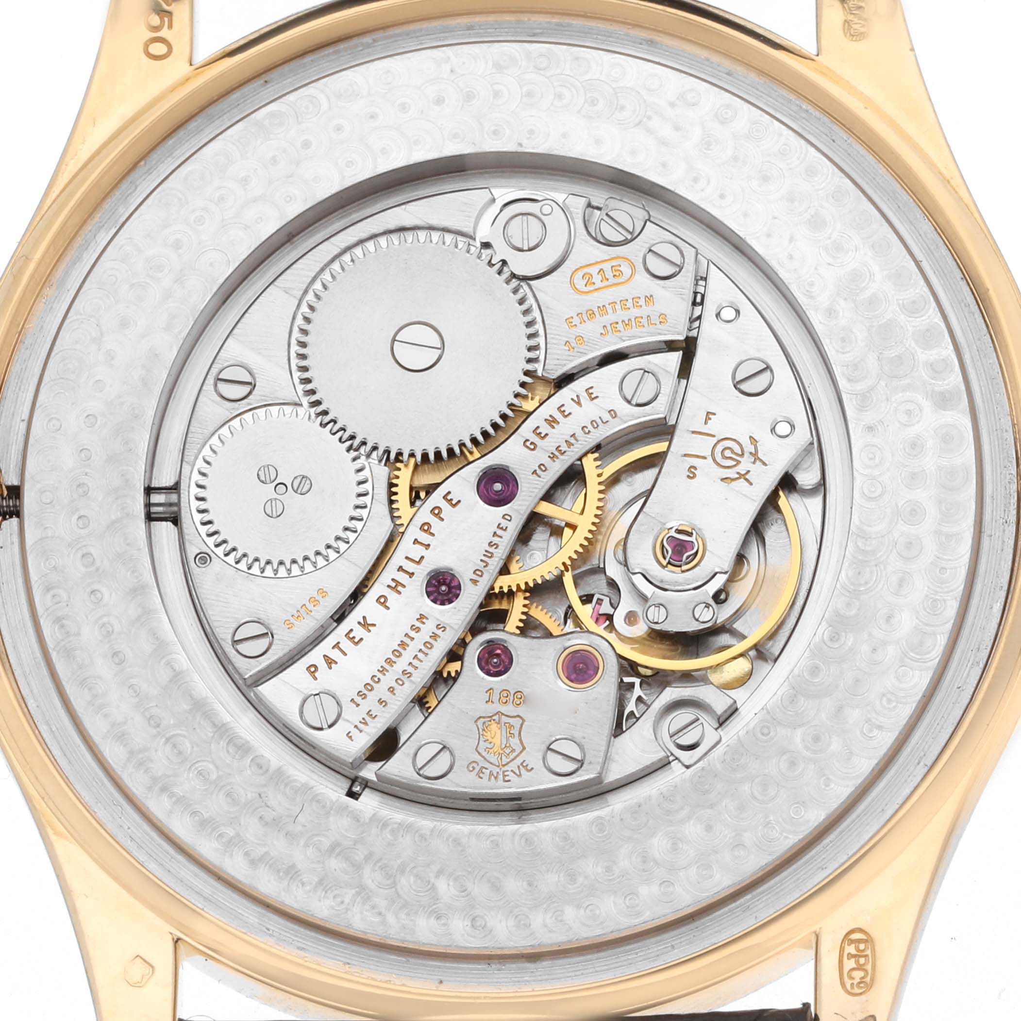 The image shows the back view of a Patek Philippe Calatrava 5196J Men's Yellow Gold Silver Dial watch, revealing its intricate movement and gears.