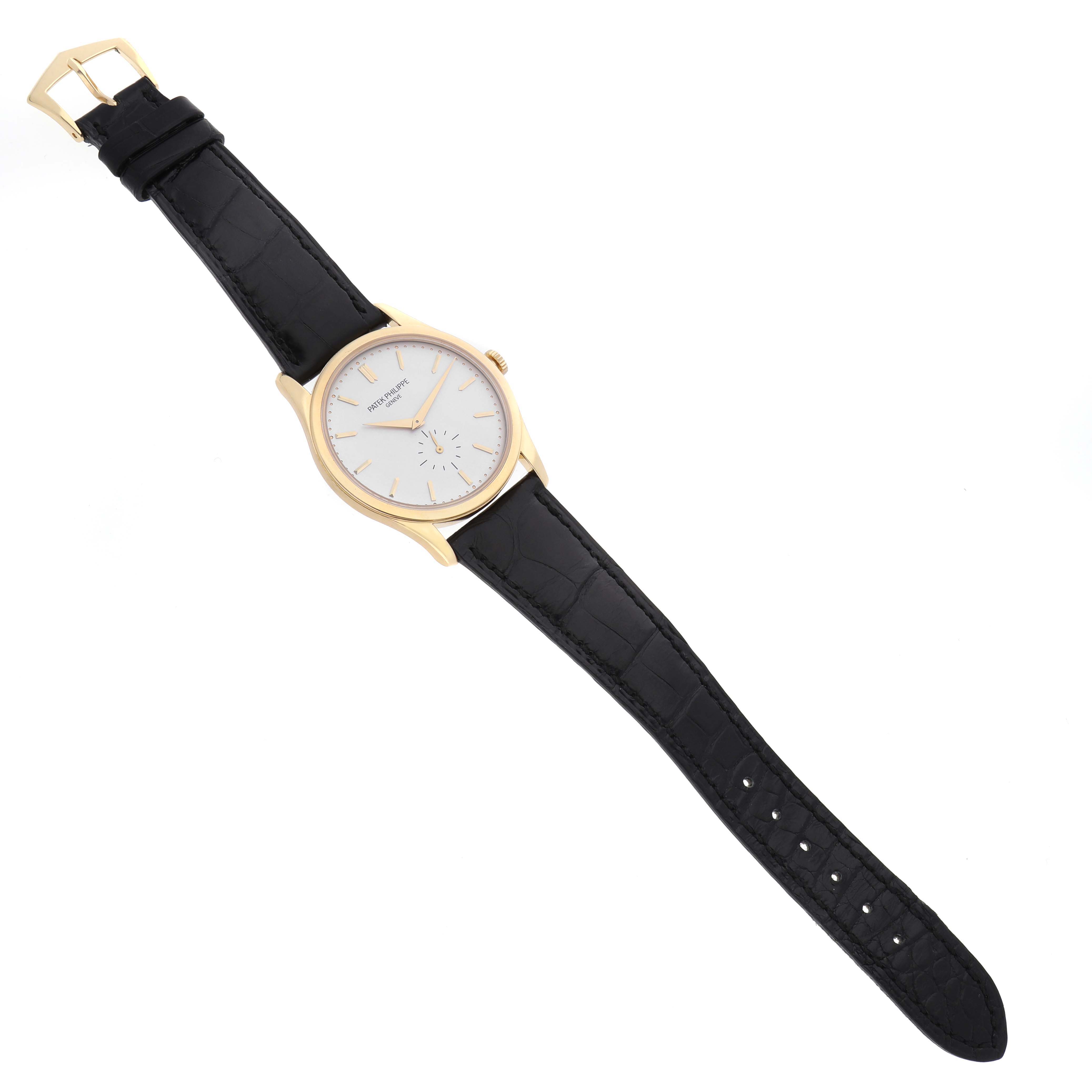 The Patek Philippe Calatrava 5196J Men's Yellow Gold Silver Dial watch is shown from a top-down angle, displaying the face, hands, crown, and black leather strap.