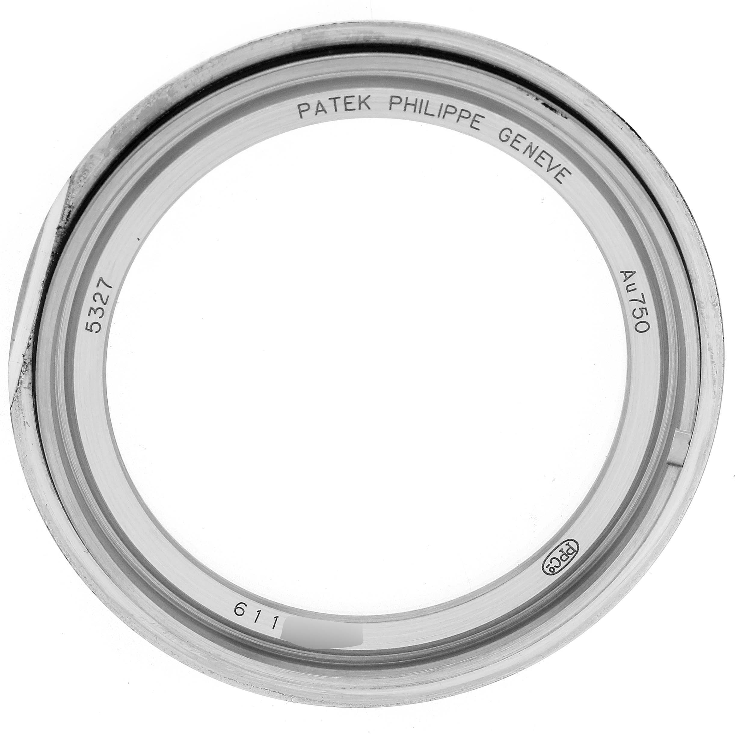 The image shows a close-up of the bezel for a Patek Philippe Complications 5327G Men
s White Gold Blue Dial model, displaying inscriptions and markings.