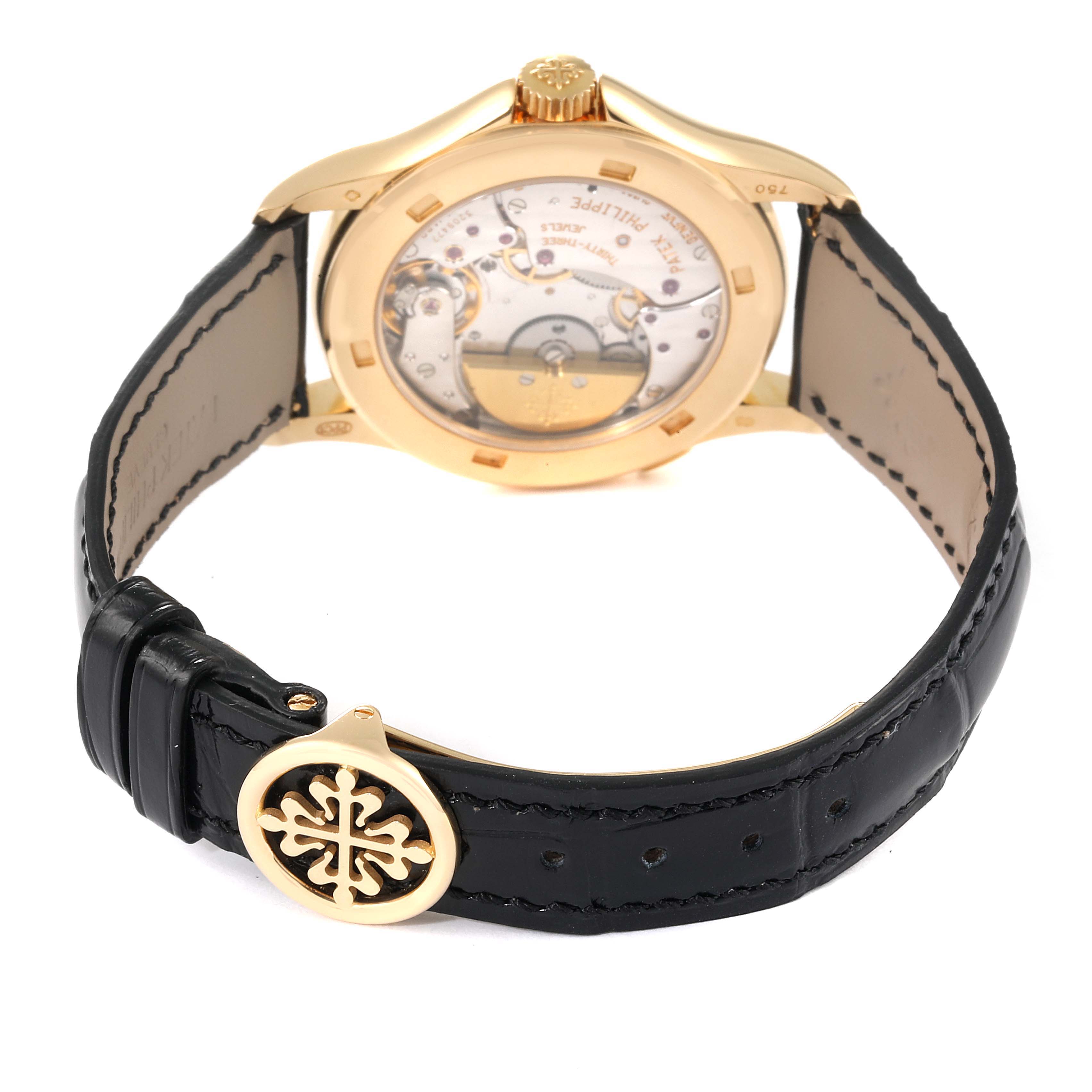 The image shows the back view of a Patek Philippe Complications 5110J Men's Yellow Gold Silver Dial 5110J Men's Yellow Gold Silver Dial watch, highlighting the movement and black leather strap with a gold clasp.