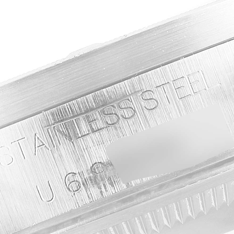 This close-up image shows the stainless steel engraved part of a Rolex Date 15210 Men's Stainless Steel Blue Dial 15210 Men's Stainless Steel Blue Dial watch case.