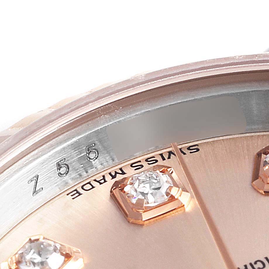 This close-up image of a Rolex Datejust 179161 Women's Rose Gold Pink Dial 179161 Women's Rose Gold Pink Dial watch shows part of the dial, diamond markers, and inner bezel with engraved serial numbers.
