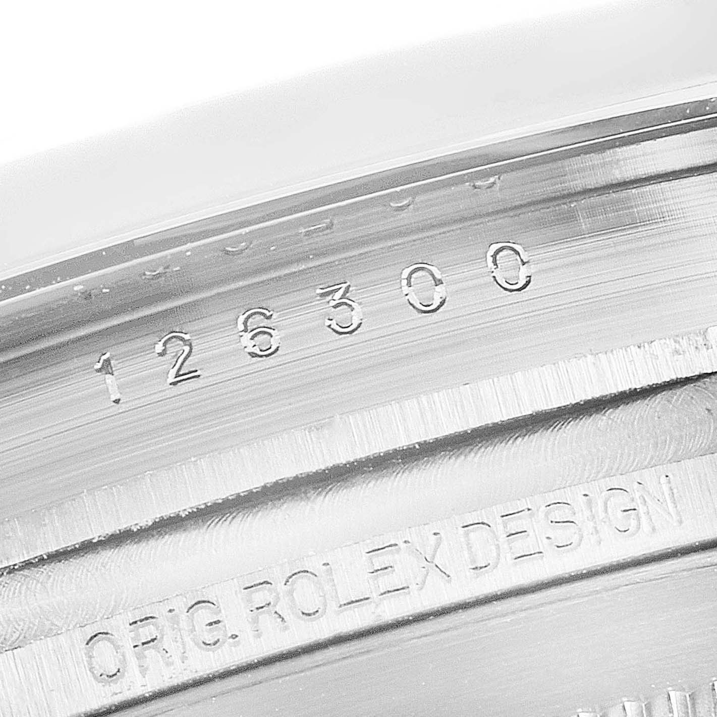 This image shows a close-up of the serial number and "ORIG. ROLEX DESIGN" engraving on the case of a Rolex Datejust 41 126300 Men's Stainless Steel Blue Dial 126300 Men's Stainless Steel Blue Dial model.