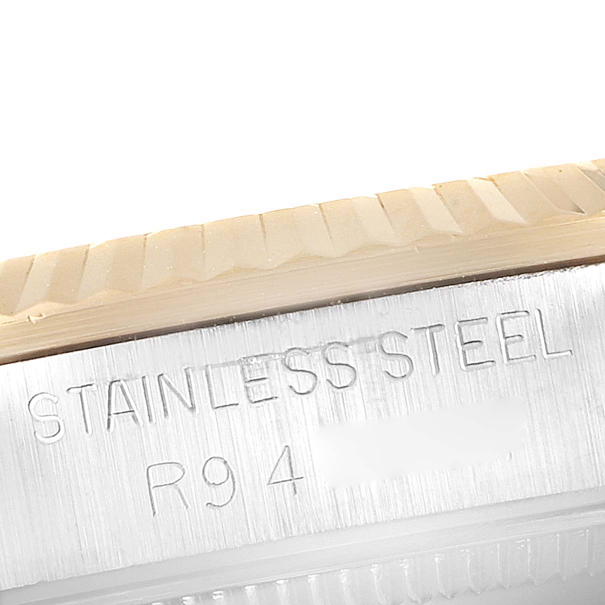 This close-up image shows the engraved stainless steel side of a Rolex Mid-Size 68273 Women's Steel and Gold (two tone) Champagne Dial 68273 Women's Steel and Gold (two tone) Champagne Dial watch with part of the bezel visible.