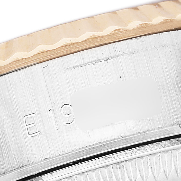 The image shows a close-up angle of the bezel and serial number area of a Rolex Datejust 69173 Women's Yellow Gold Black Dial.