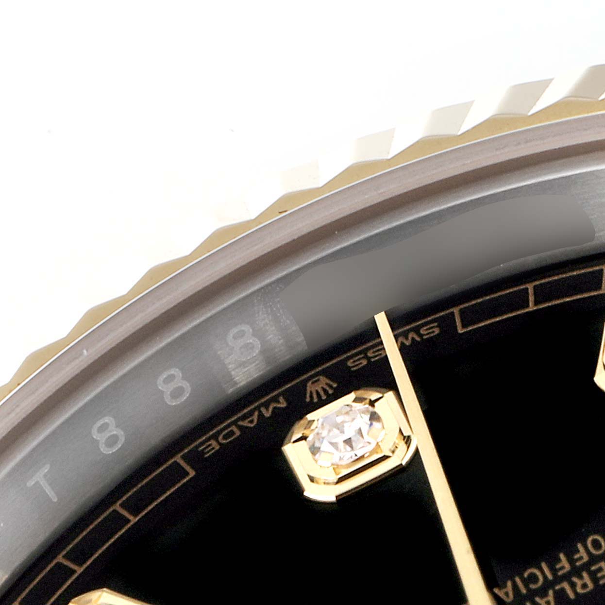 This close-up image of the Rolex Datejust 41 126333 Men's Steel and Gold (two tone) Black Dial 126333 Men's Steel and Gold (two tone) Black Dial watch shows the bezel and part of the dial with a diamond marker.