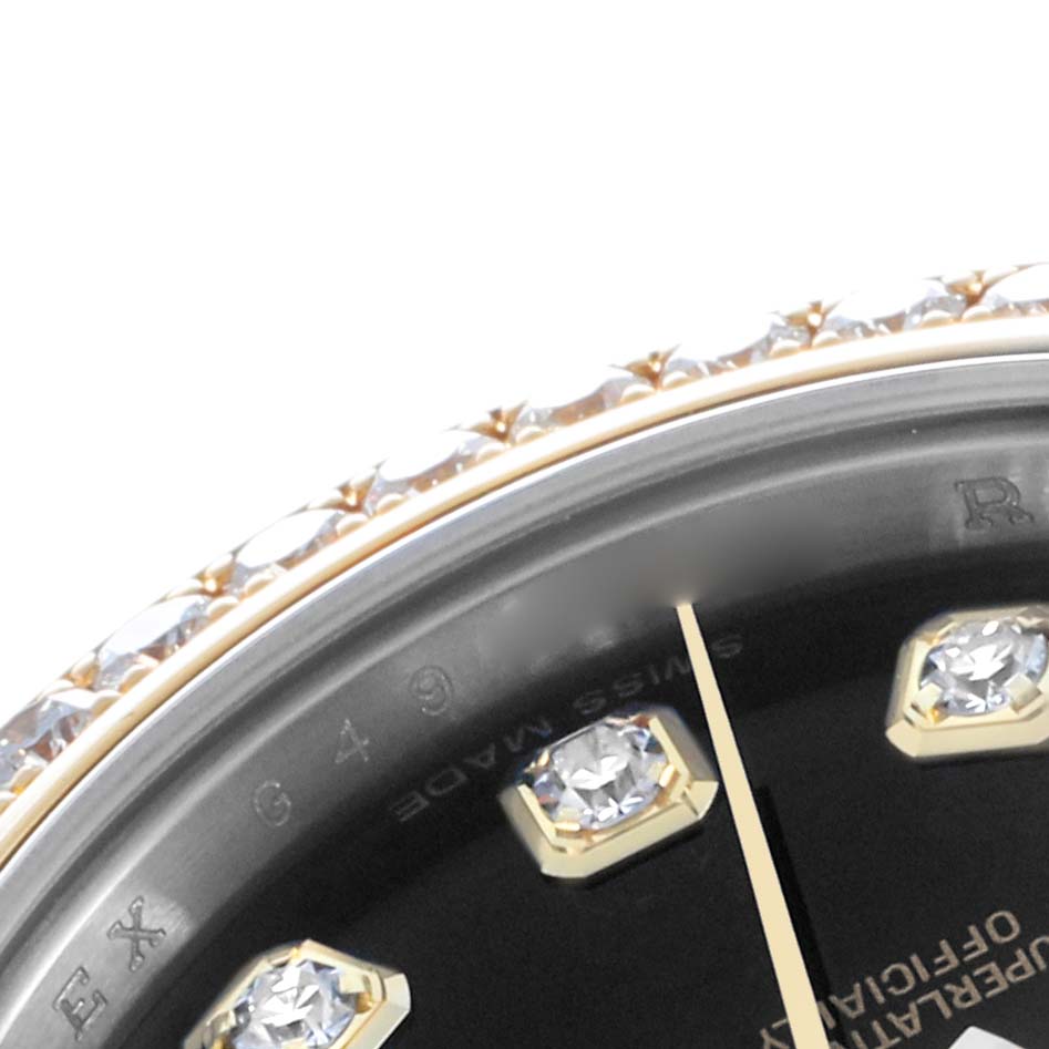 This close-up of the Rolex Datejust 179383 Women
s Steel and Gold (two tone) Black Dial watch shows part of the bezel with diamonds, index markers, and the minute hand.