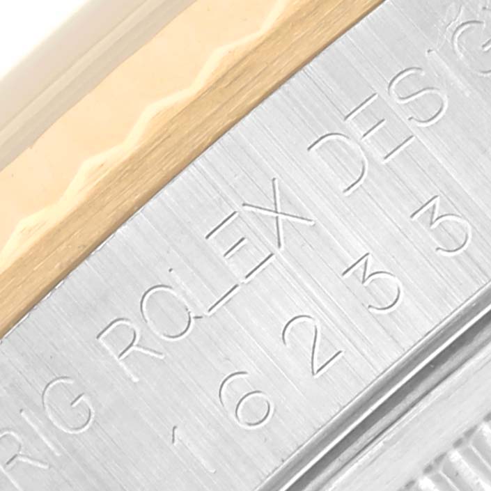 The image shows a close-up of the engraved bezel edge of a Rolex Datejust 16233 Men
s Steel and Gold (two tone) White Dial 16233 Men
s Steel and Gold (two tone) White Dial watch.