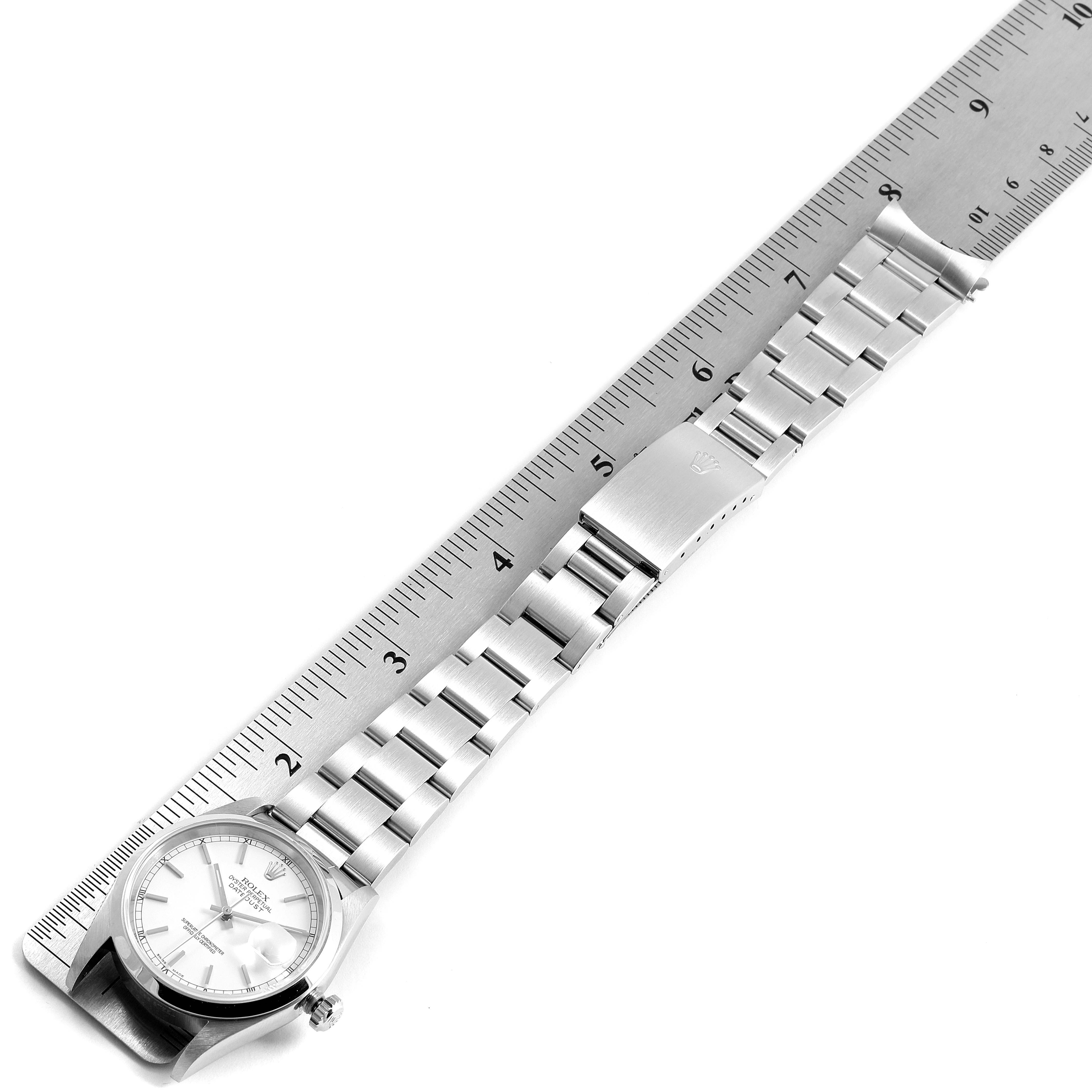 The image shows a top view of a Rolex Datejust 16200 Men's Stainless Steel White Dial 16200 Men's Stainless Steel White Dial watch laid across a ruler, displaying the face and bracelet.