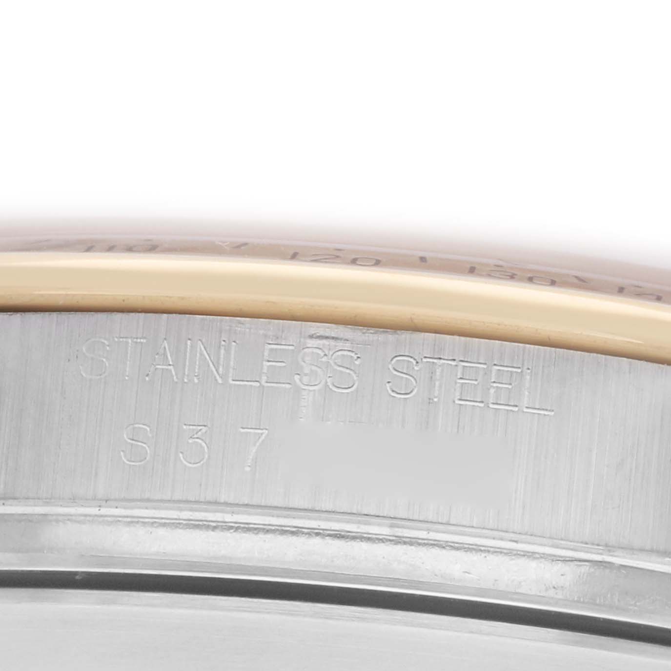 The image shows a close-up of the side of a Rolex Daytona 16523 Men
s Steel and Gold (two tone) Champagne Dial, displaying "STAINLESS STEEL" engraving.