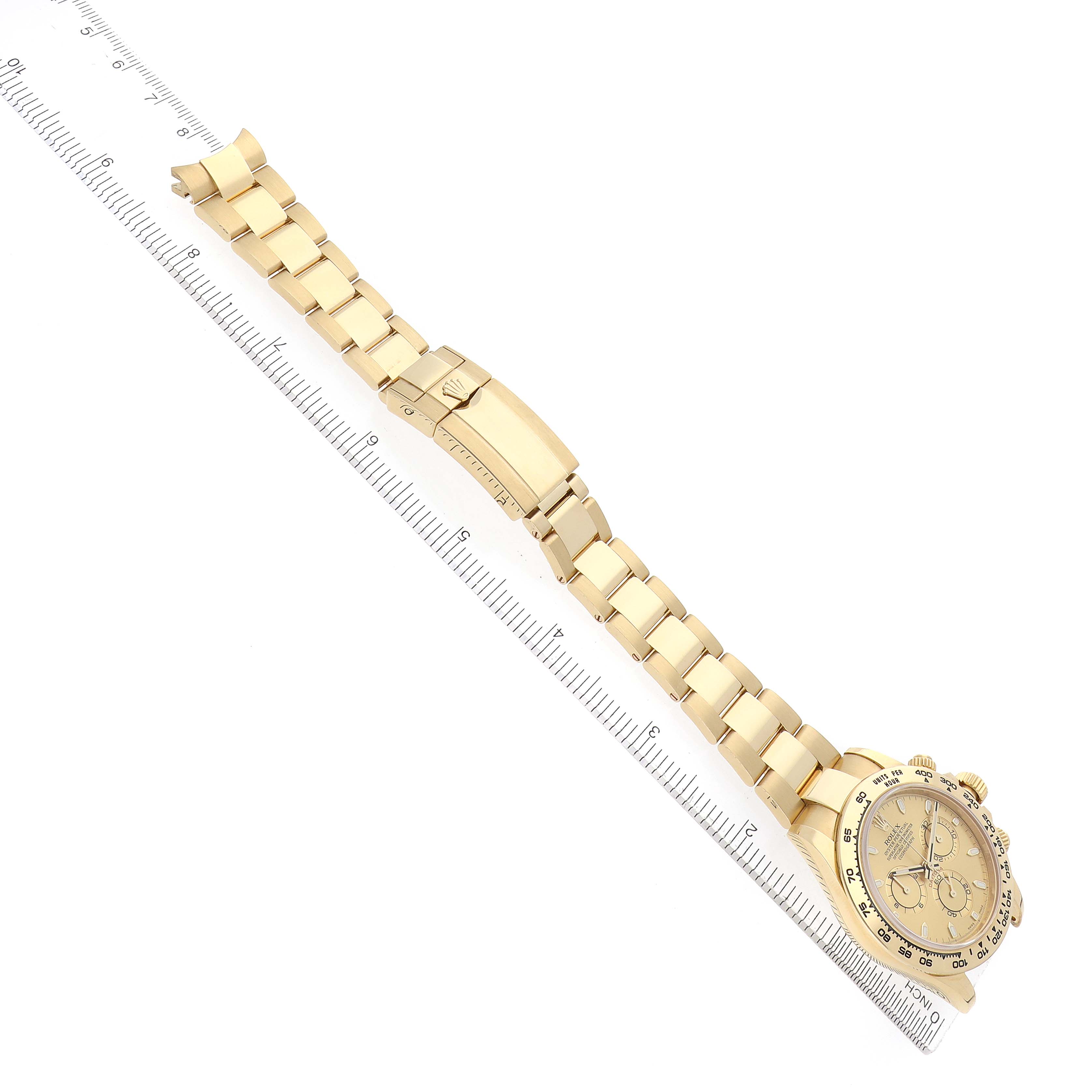 The image shows a Rolex Daytona 116508 Men
s Yellow Gold Champagne Dial watch laid flat with a ruler, displaying its bracelet, clasp, and face from an overhead angle.