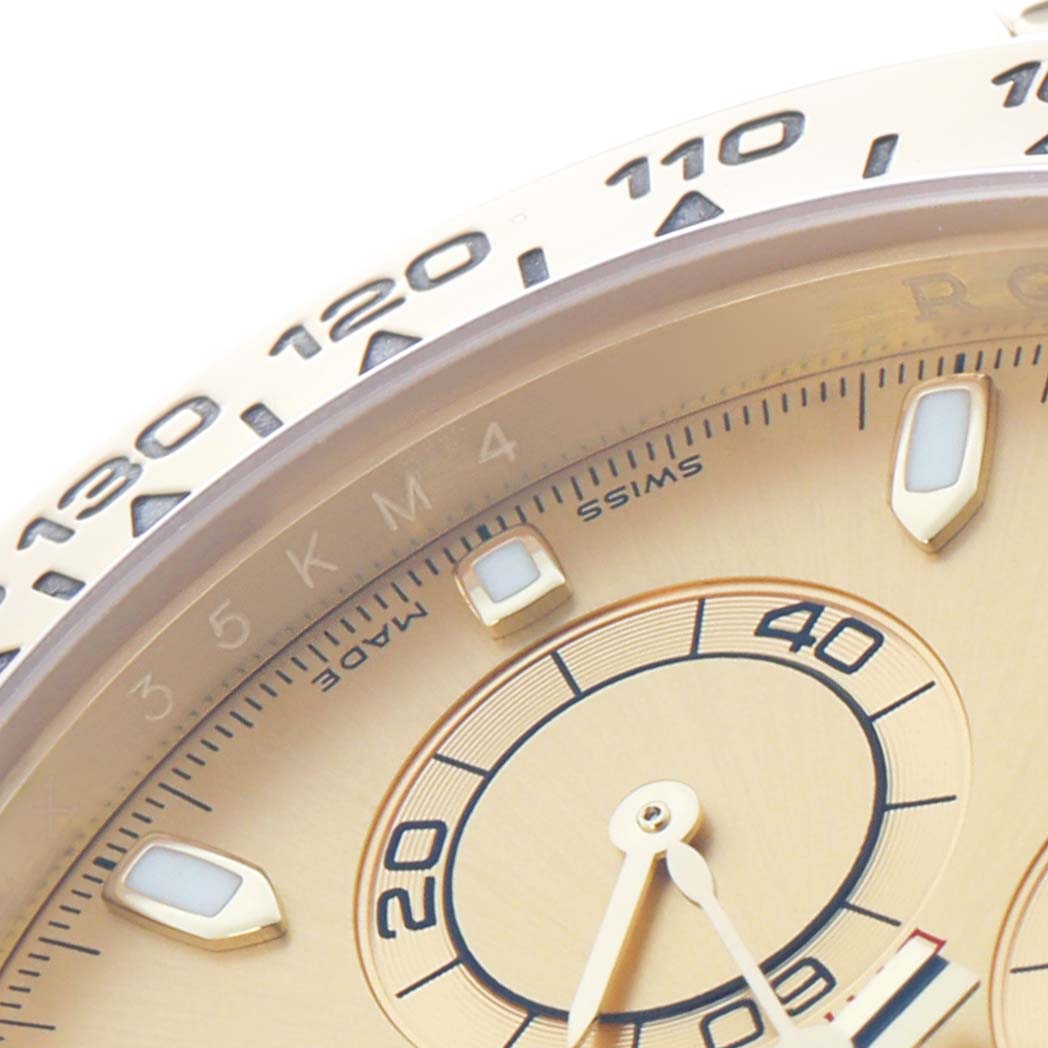 The image shows a close-up of the Rolex Daytona 116508 Men
s Yellow Gold Champagne Dial
s bezel and part of the dial with hour markers and hands.