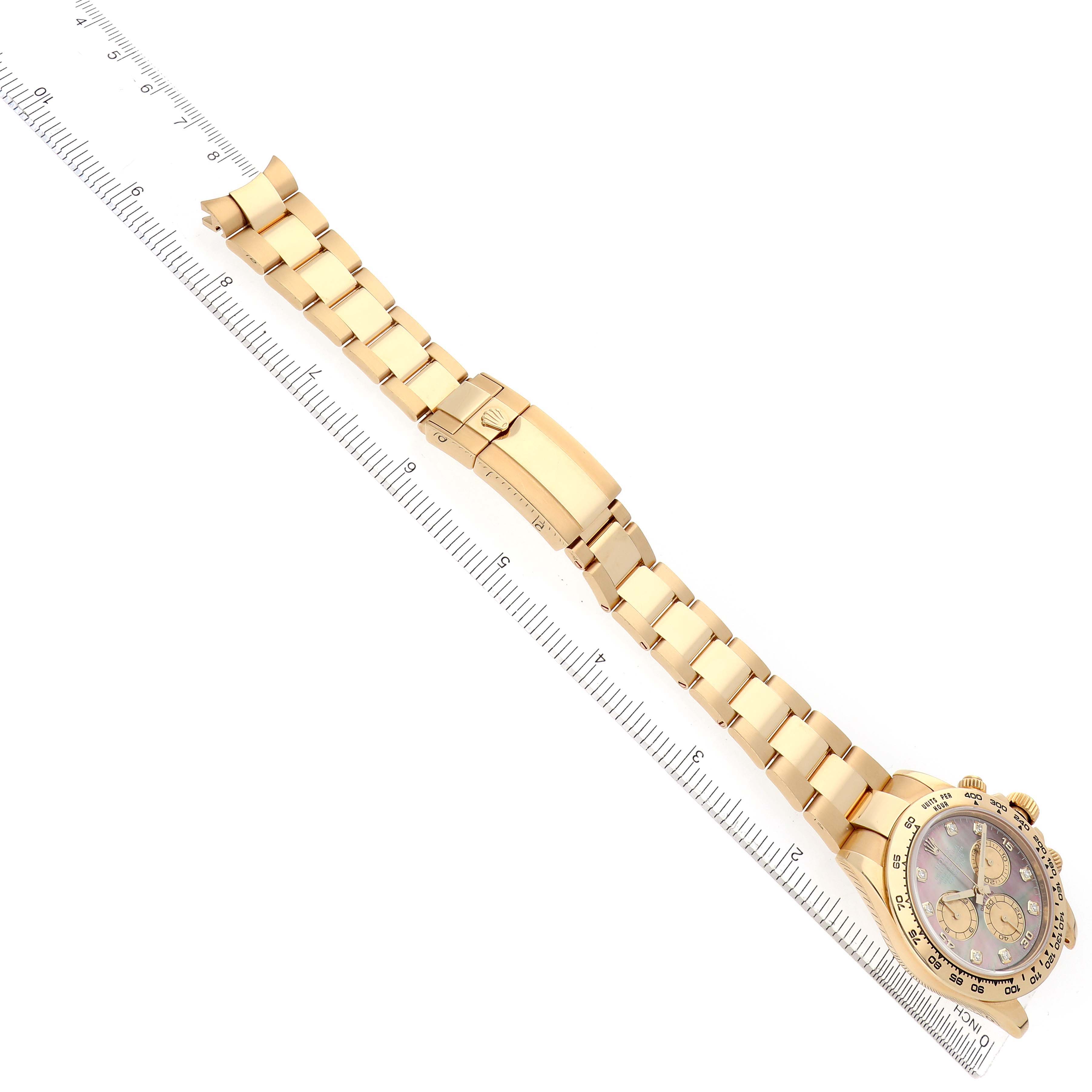 The Rolex Daytona 116508 Men
s Yellow Gold Mother of Pearl Dial watch is shown at a high angle, highlighting the bracelet and partial view of the face alongside a ruler.