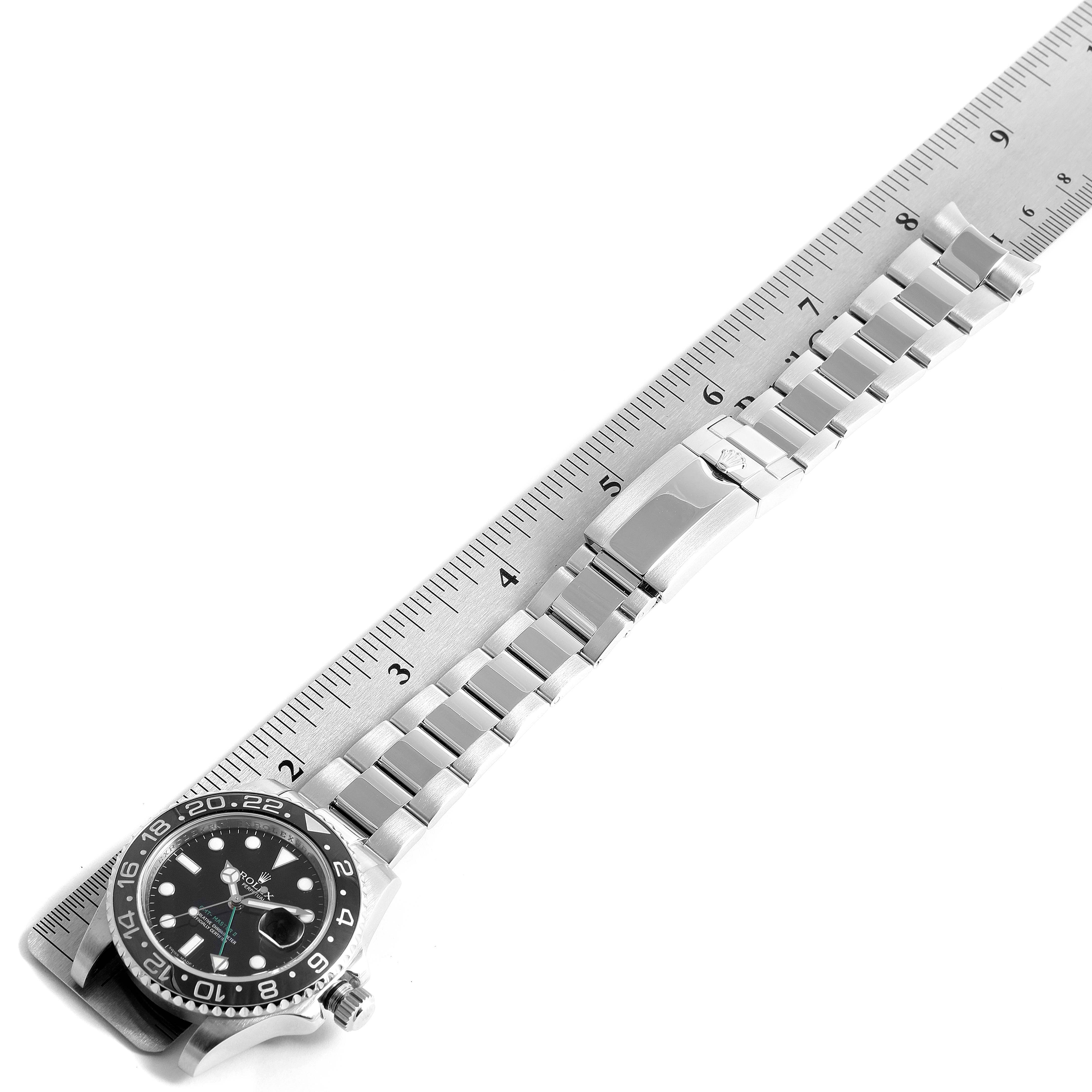 The image displays a Rolex GMT-Master 116710 Men's Stainless Steel Black Dial 116710 Men's Stainless Steel Black Dial watch laid flat, showing its face, bezel, and bracelet alongside a ruler for scale.