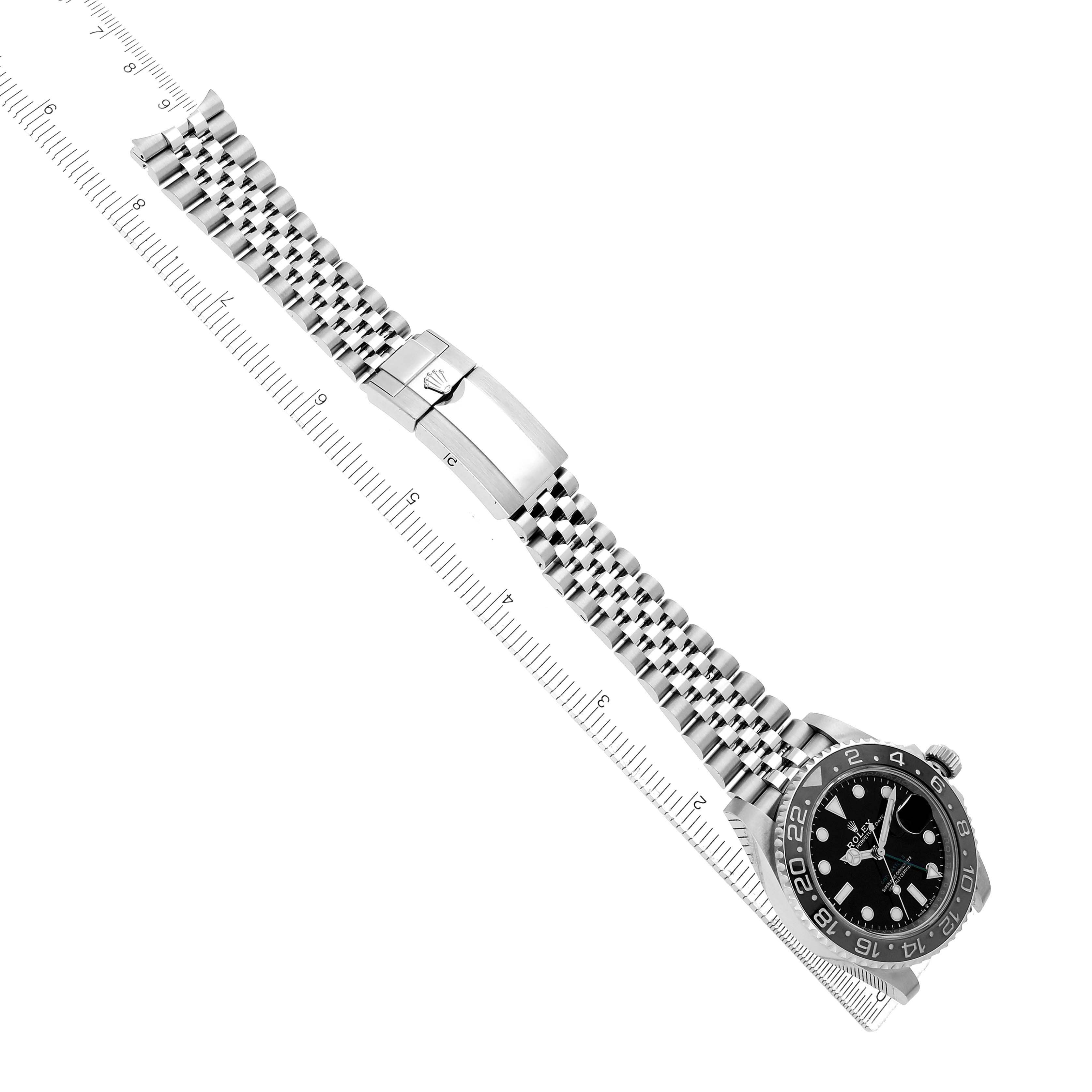 The Rolex GMT-Master 126710 Men's Stainless Steel Black Dial is shown at an angled top view, displaying the bracelet, clasp, and watch face alongside a ruler for scale.