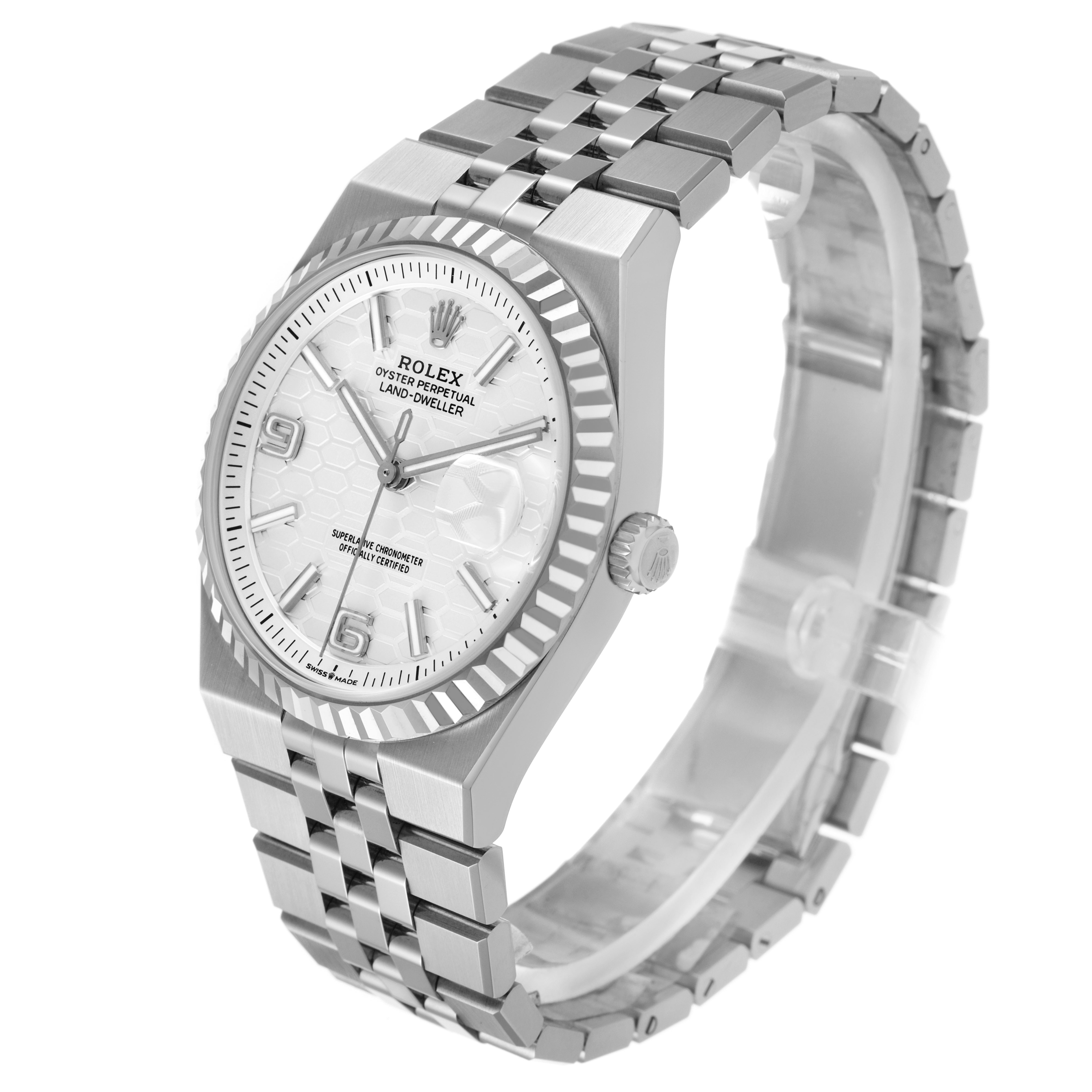 The Rolex Land-Dweller watch is shown at an angle highlighting the face, bezel, crown, and bracelet.
