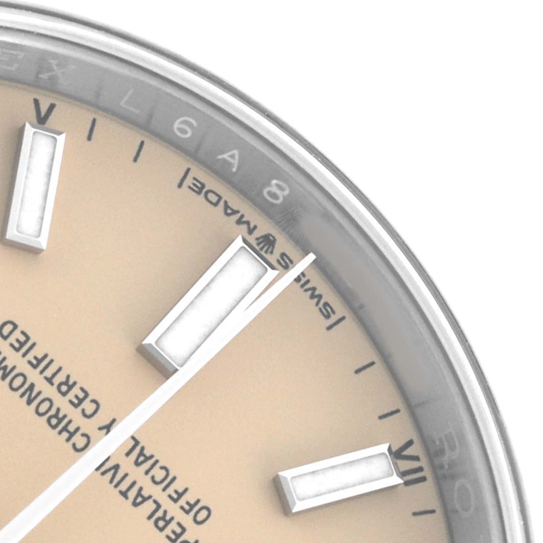 The image shows a close-up of the Rolex Oyster Perpetual 124200 Men
s Stainless Steel Beige Dial watch
s dial, highlighting the hour markers and minute hand.