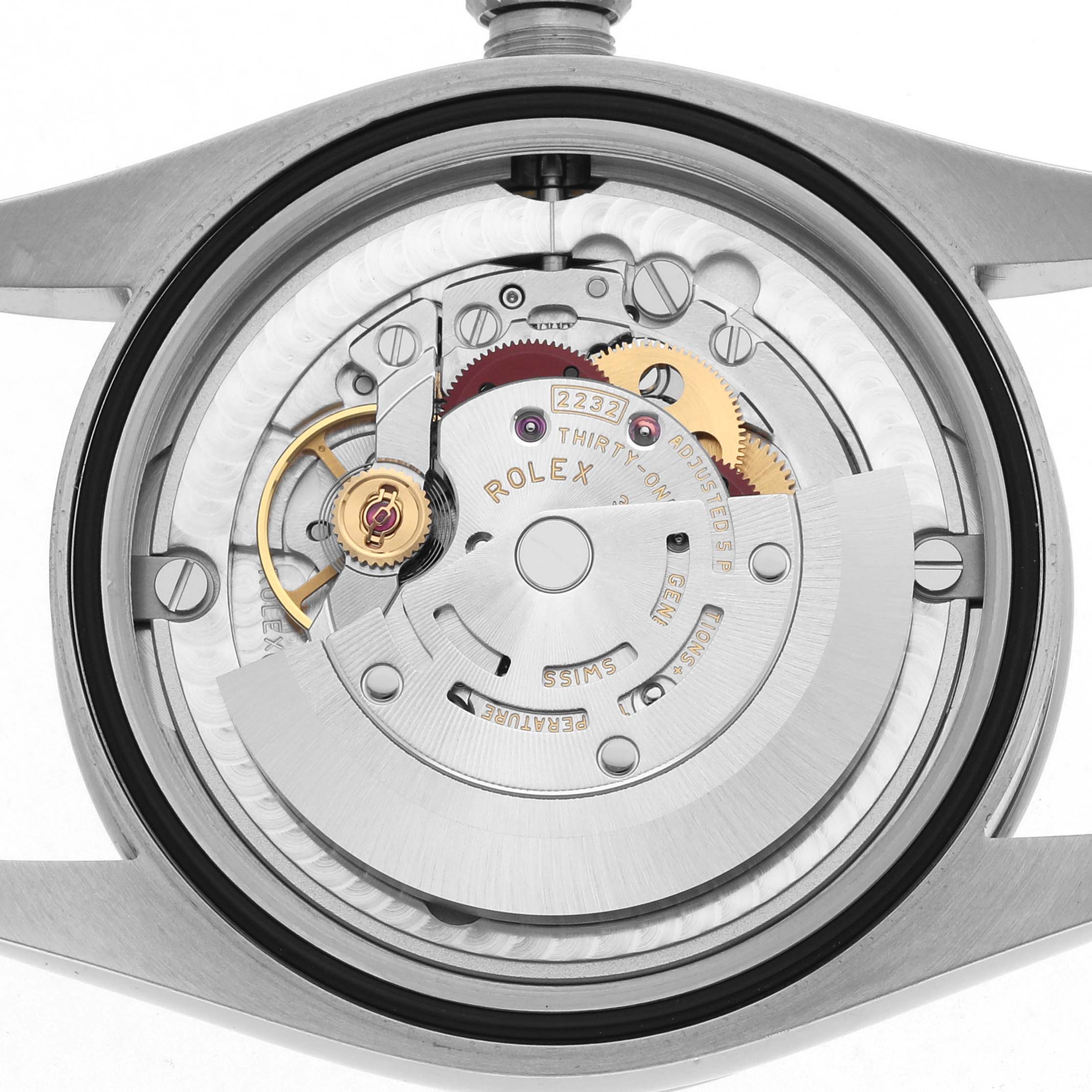 The image shows the internal movement of a Rolex Oyster Perpetual 124200 Men
s Stainless Steel Green Dial watch from a top-down angle, exposing gears and components.