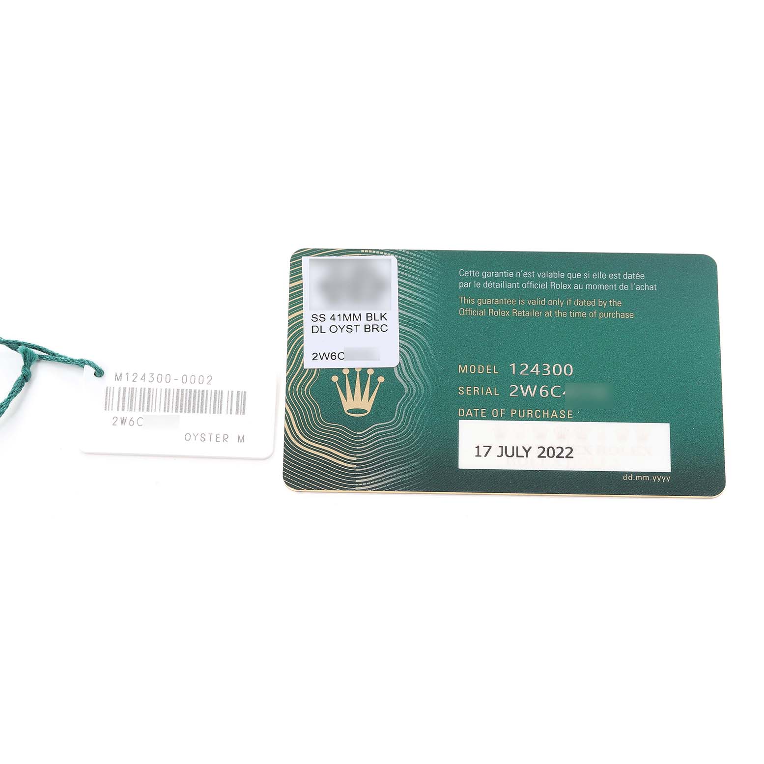 This image shows the warranty card and tag for a Rolex Oyster Perpetual 124300 Men
s Stainless Steel Black Dial 124300 Men
s Stainless Steel Black Dial model 124300 with serial number 2W6C.