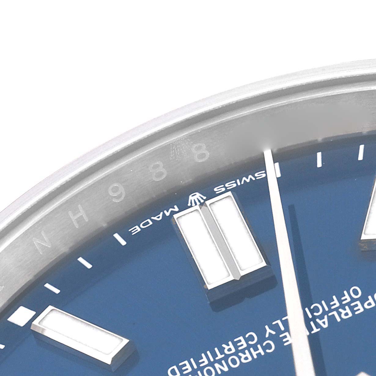 A close-up shot of the Rolex Oyster Perpetual 124300 Men
s Stainless Steel Blue Dial 124300 Men
s Stainless Steel Blue Dial watch shows part of the blue dial, hour markers, and the "Swiss Made" inscription.