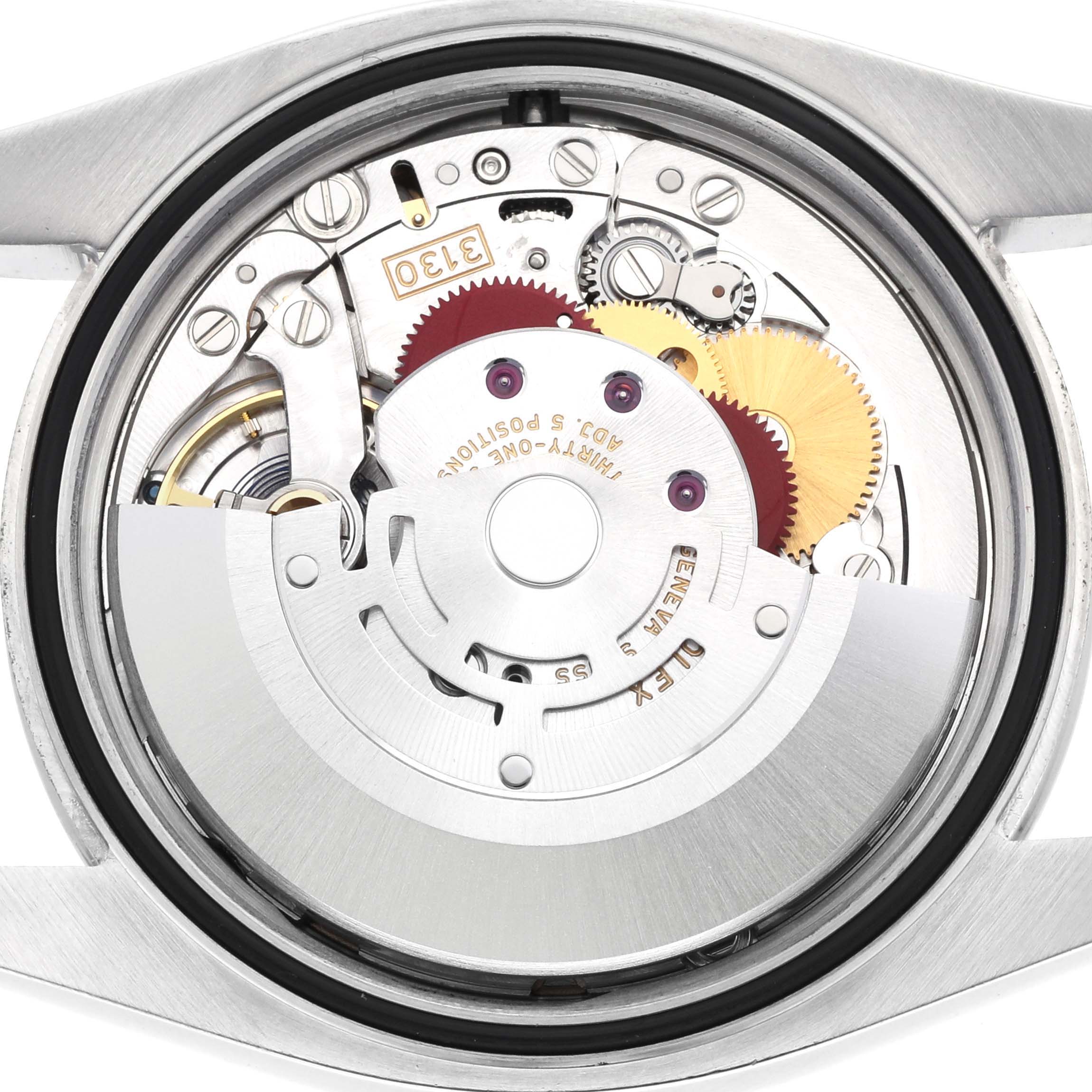 The image shows the internal movement of a Rolex Oyster Perpetual 116000 Men's Stainless Steel Purple Dial watch viewed from the back, highlighting gears and components.