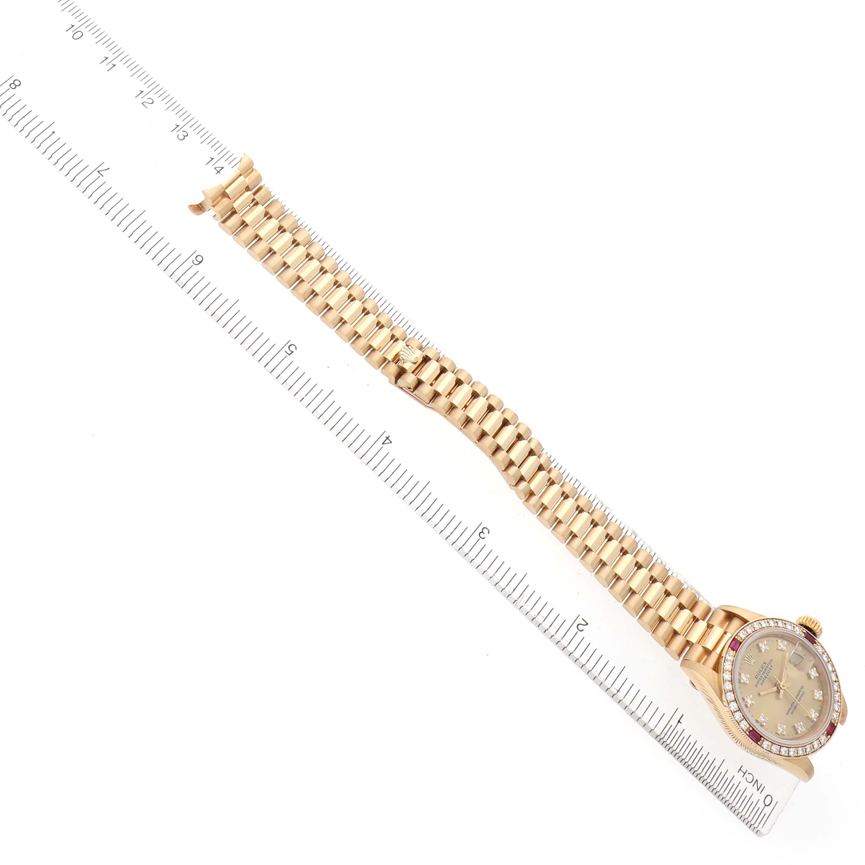 The Rolex President 69068 Women
s Yellow Gold Champagne Dial watch is shown from a top angle, displaying the bracelet, case, and bezel alongside a ruler for scale.