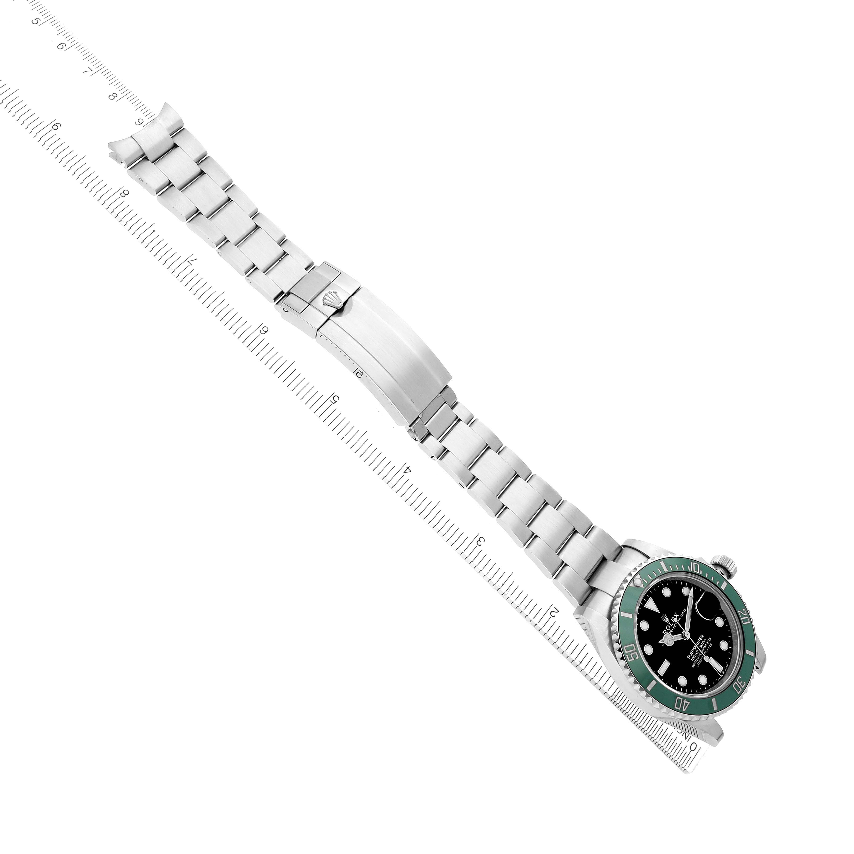 The Rolex Submariner 126610 Men
s Stainless Steel Black Dial watch is shown from a top view, displaying the entire band and dial, set against a measuring ruler.