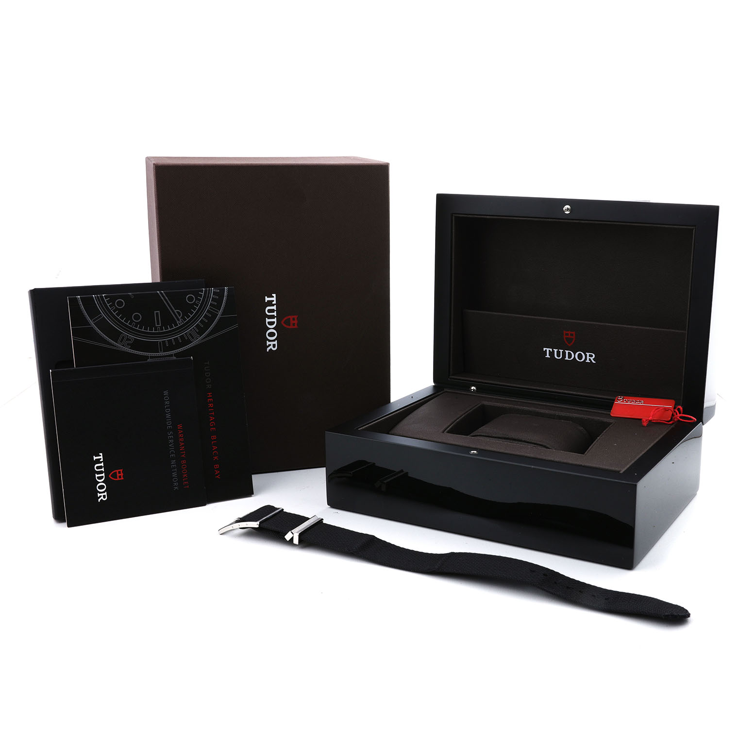 The image shows Tudor Heritage Black Bay 79220R Men's Stainless Steel Black Dial packaging, including the box, manuals, and an extra strap, viewed from an angled perspective.