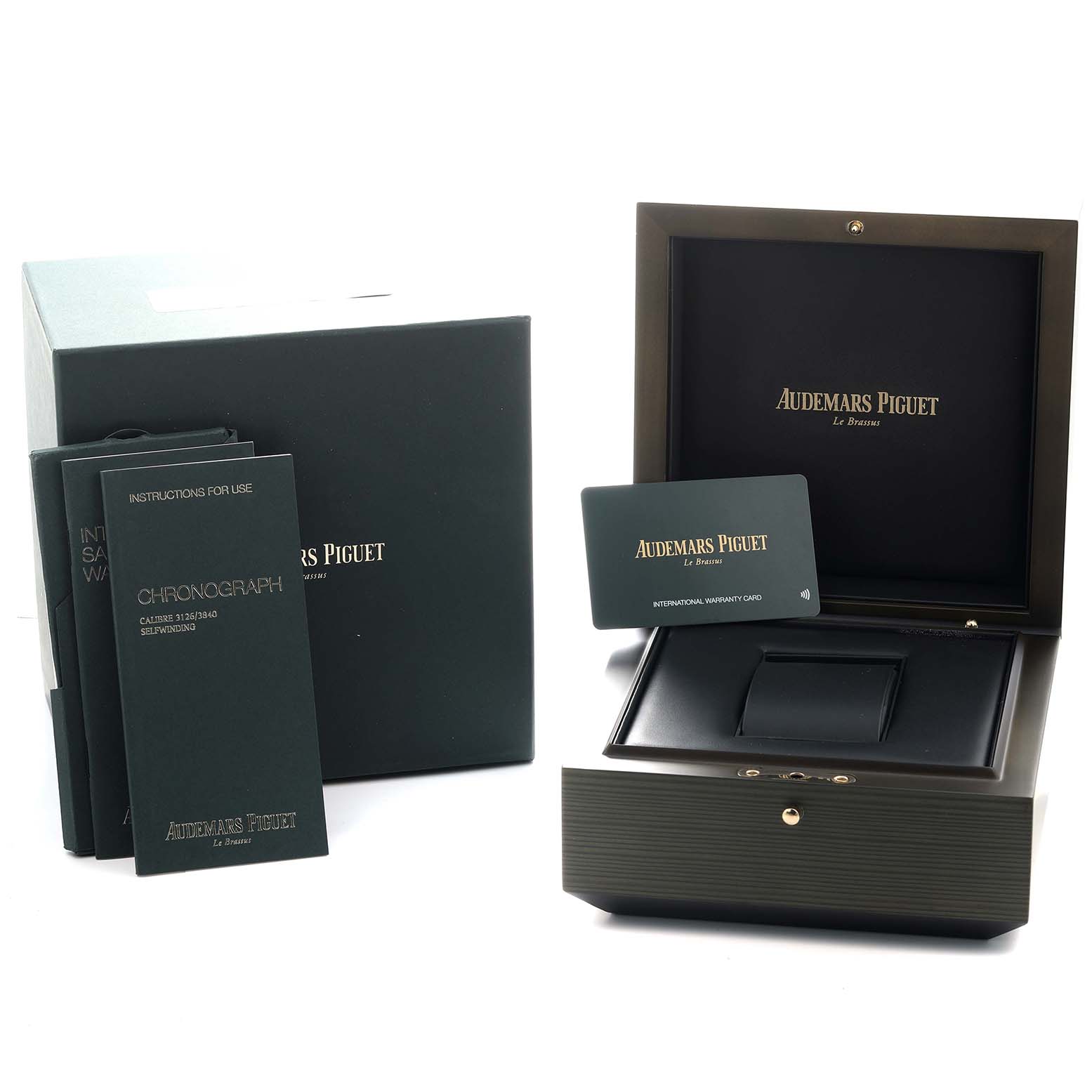 The image shows the packaging and accessories of the Audemars Piguet Royal Oak Offshore 26400IO Men's Titanium Grey Dial, including the box, manuals, and warranty card.