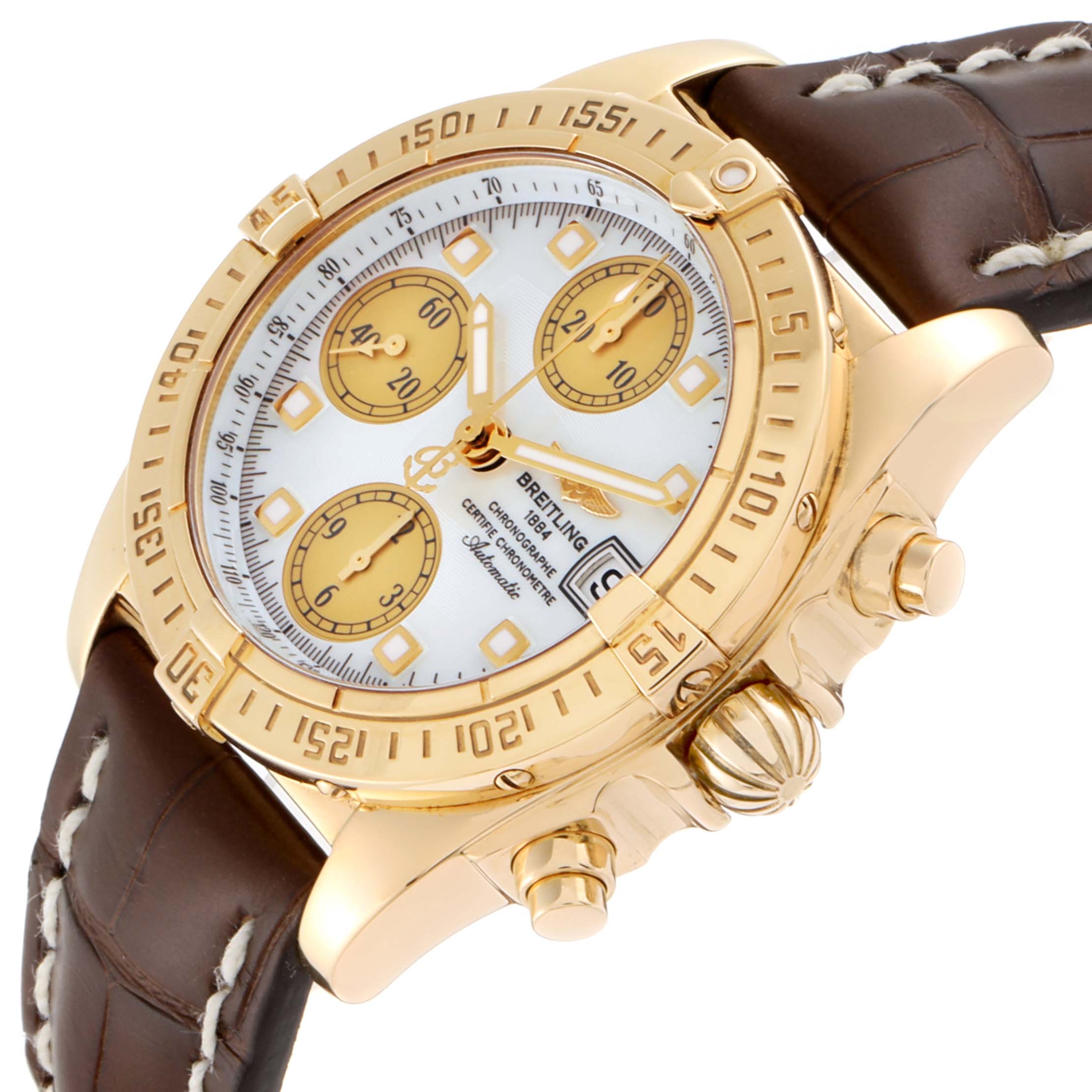 The Breitling Windrider K13358 Men's Yellow Gold Mother of Pearl Dial K13358 Men's Yellow Gold Mother of Pearl Dial watch is shown at an angled side view, displaying its gold case, chronograph dials, and brown leather strap.