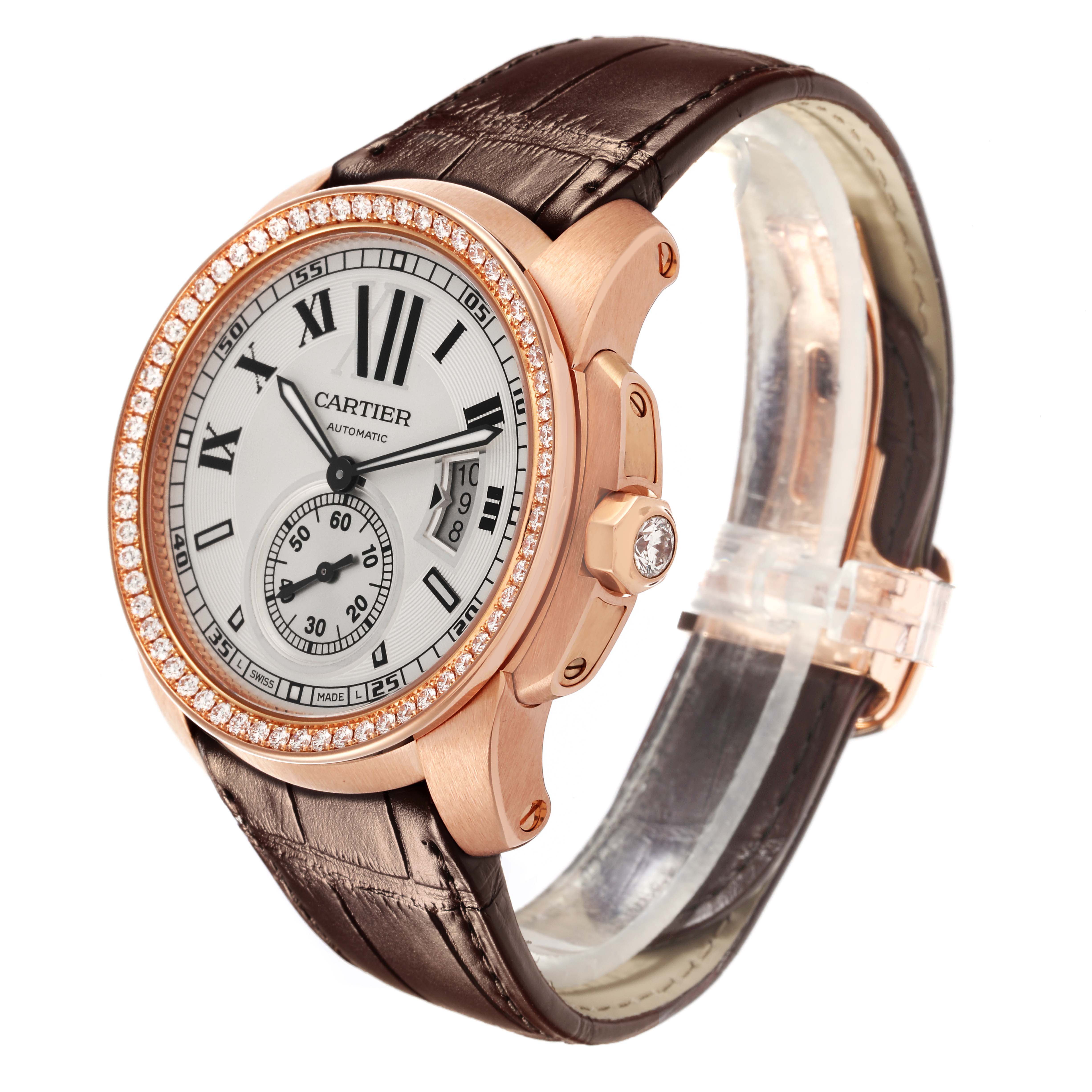 The Calibre de Cartier watch is shown at an angle highlighting the dial, bezel, crown, and leather strap.
