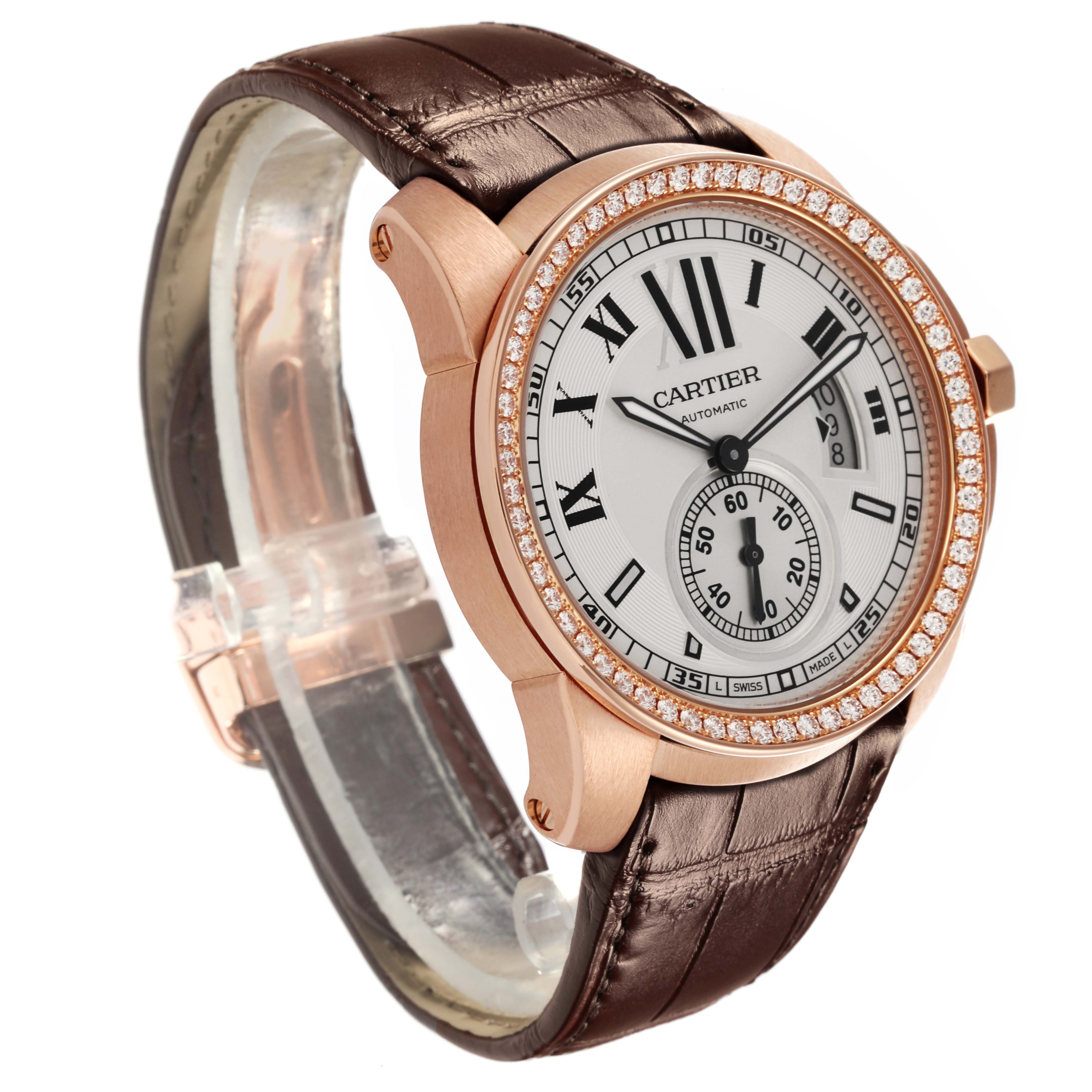 The Calibre de Cartier watch is shown at a three-quarter angle, displaying the face, case, bezel, and leather strap.