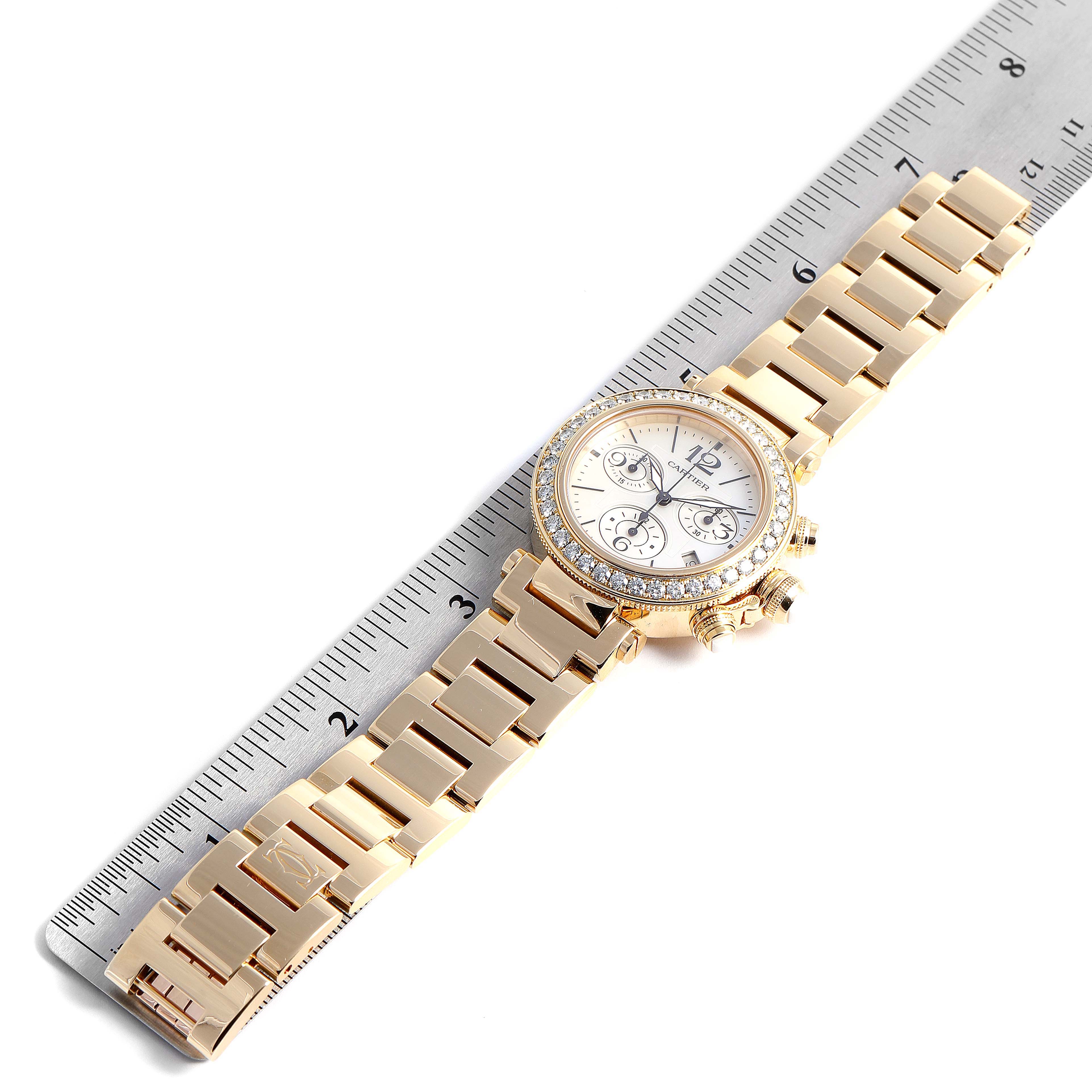 This image shows a Cartier Pasha WJ130007 Women's Yellow Gold Mother of Pearl Dial WJ130007 Women's Yellow Gold Mother of Pearl Dial watch laid flat and measured against a ruler for scale.