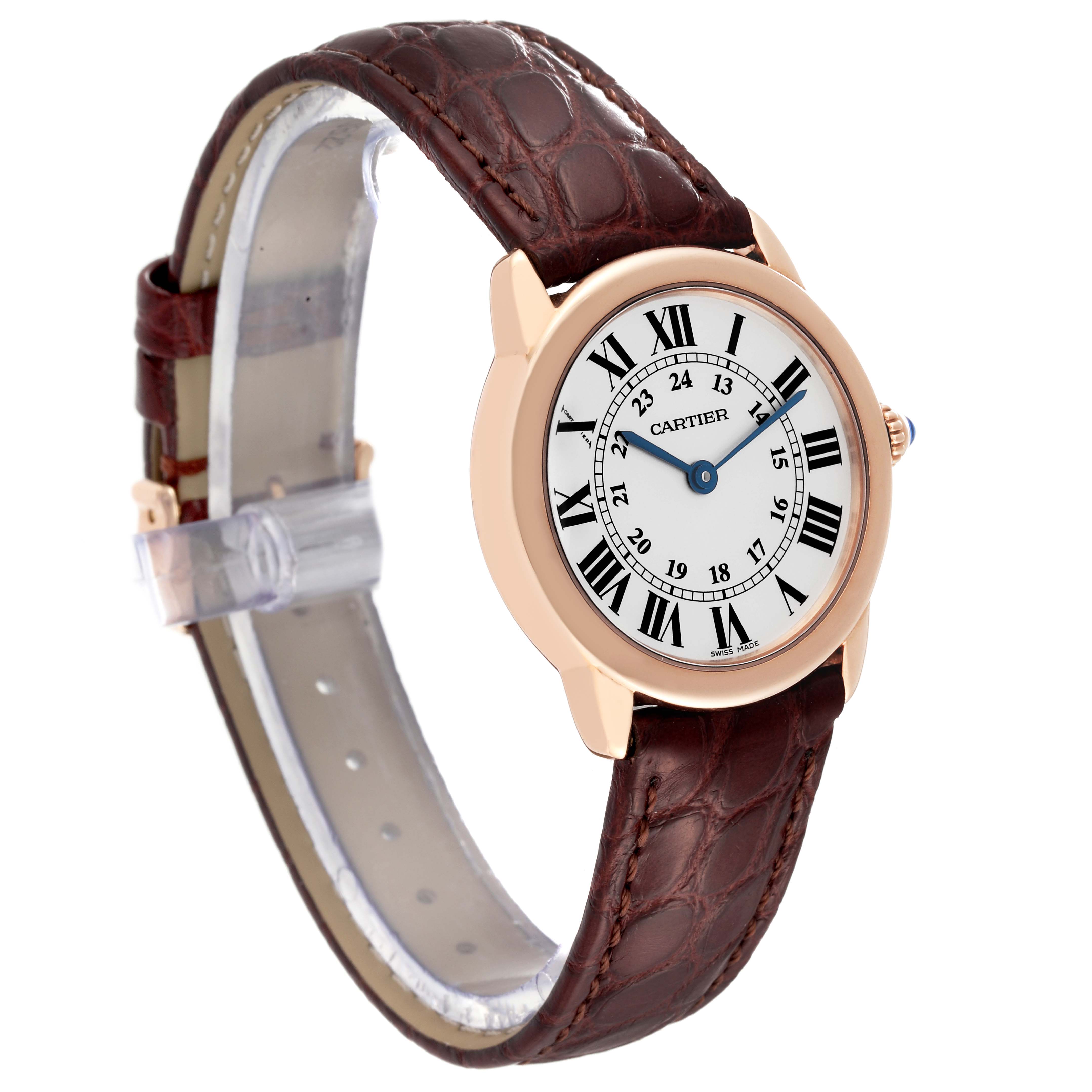 The Cartier Ronde W6701007 Women's Rose Gold Silver Dial W6701007 Women's Rose Gold Silver Dial model watch is shown at a three-quarter angle, displaying its round face, Roman numerals, and brown leather strap.