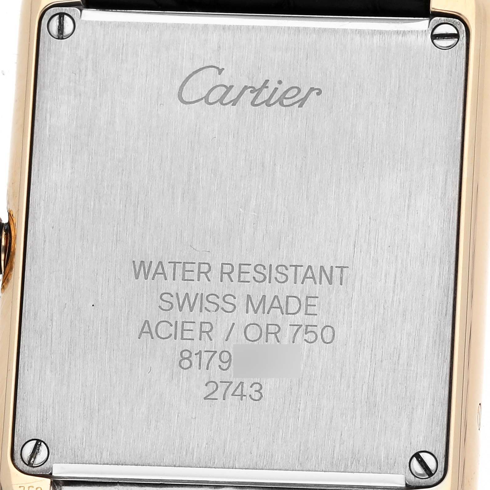 The image shows the back case of a Cartier Tank Solo W1018755 Women's Steel and Gold (two tone) Silver Dial watch, displaying the brand name, material details, and serial number.