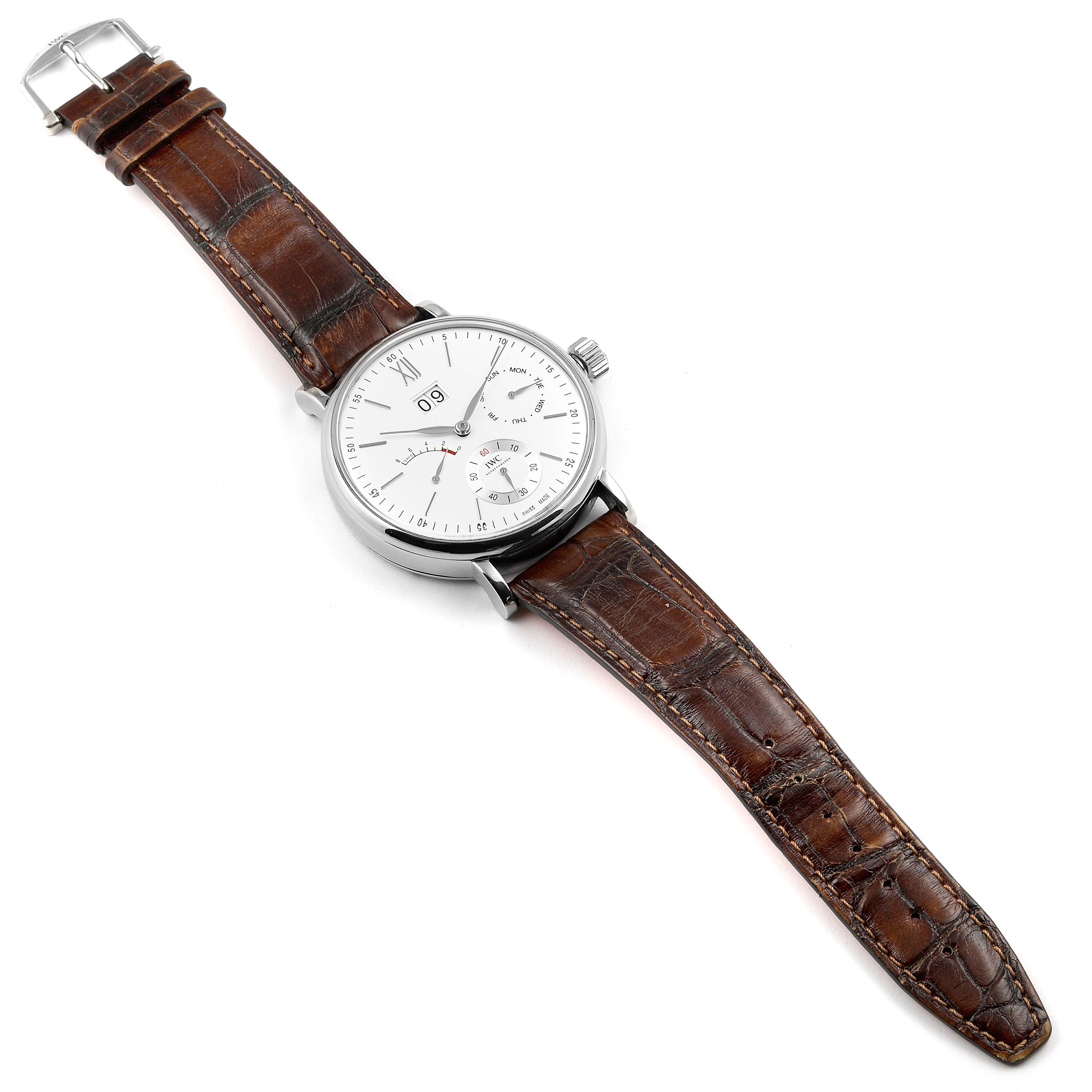 The image shows an IWC Portofino IW516201 Men's Stainless Steel Silver Dial IW516201 Men's Stainless Steel Silver Dial watch at an angled top-down view, displaying its brown leather strap and white dial. 