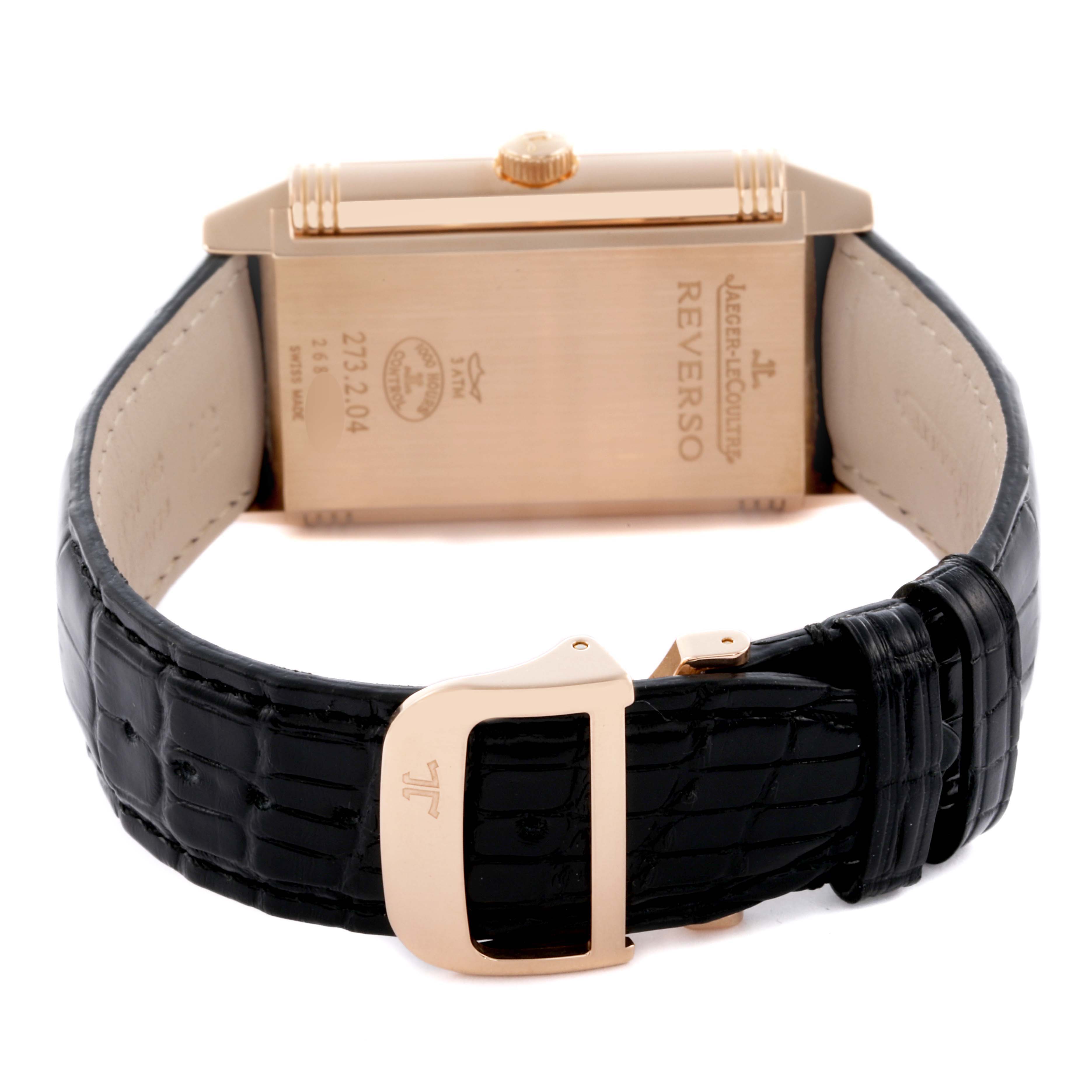 The image shows the back view of the Jaeger-LeCoultre Reverso watch, highlighting the case, crown, and black leather strap with a clasp.