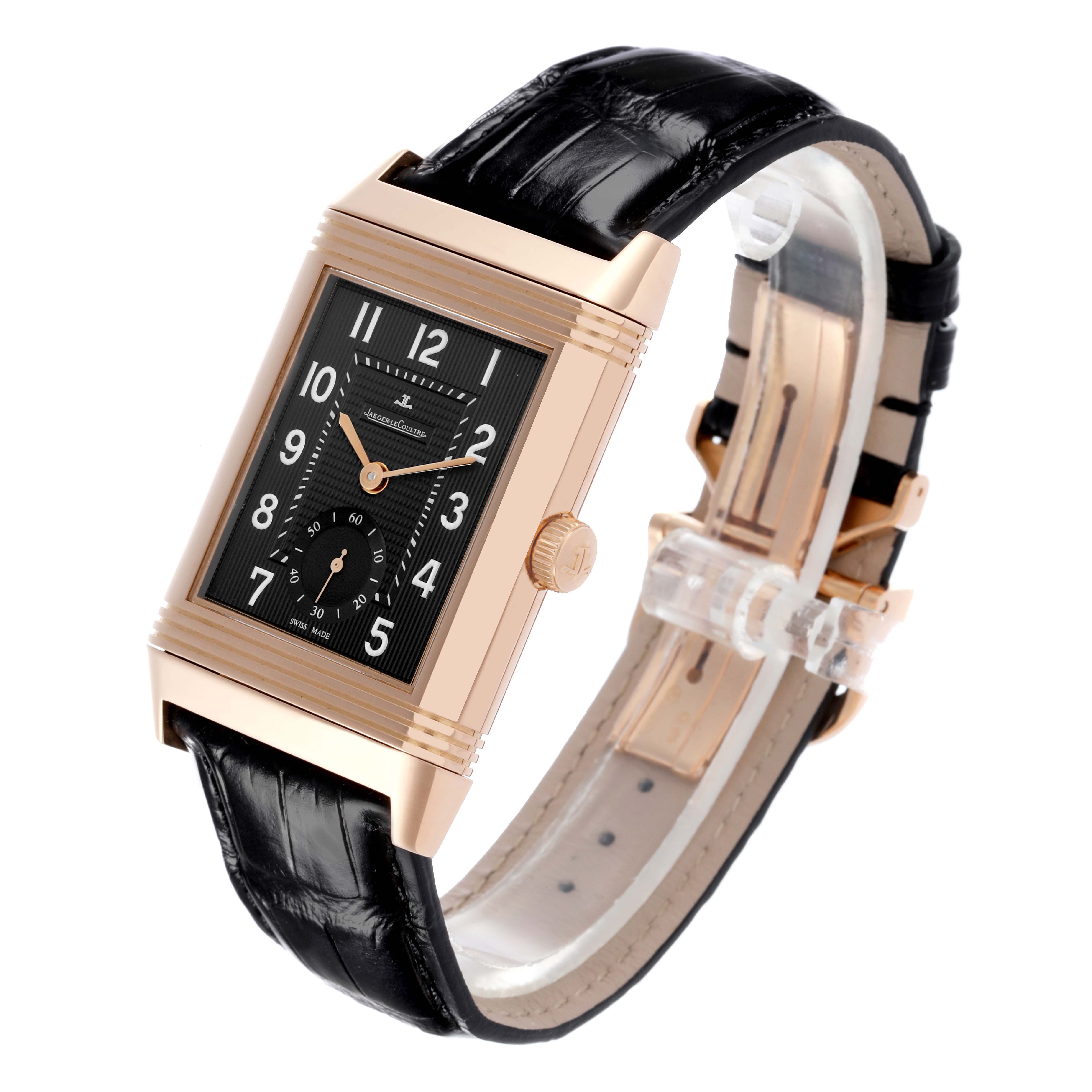 The Jaeger-LeCoultre Reverso watch is shown at an angle that highlights the face, case, and black leather strap.