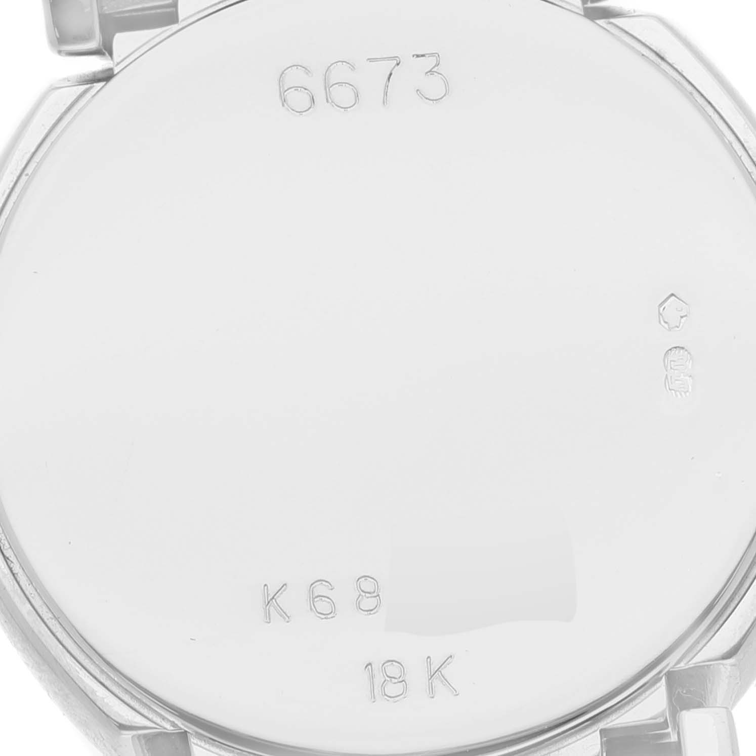 This image shows the back case of a Rolex Cellini 6673 Women's White Gold Silver Dial 6673 Women's White Gold Silver Dial model watch with engraved details and hallmarks.