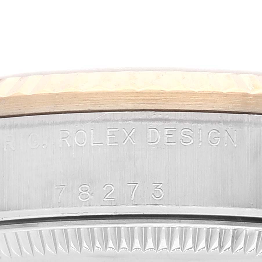 The image shows a close-up of the side engraving and part of the bezel of a Rolex Mid-Size 78273 Women
s Steel and Gold (two tone) Champagne Dial 78273 Women
s Steel and Gold (two tone) Champagne Dial model watch.