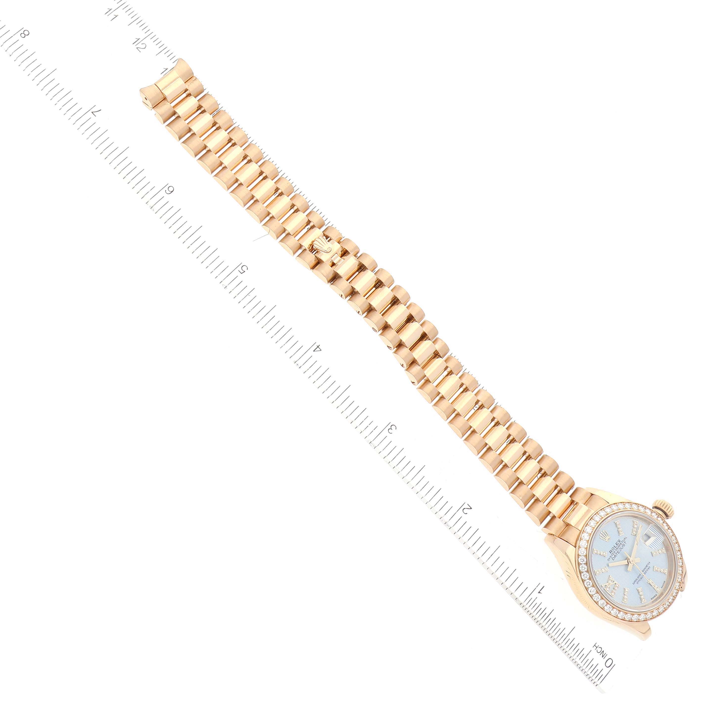 This image shows an overhead view of the Rolex President 279138 Women's Yellow Gold Blue Dial 279138 Women's Yellow Gold Blue Dial model watch, displaying the bracelet and the face with a ruler for scale.
