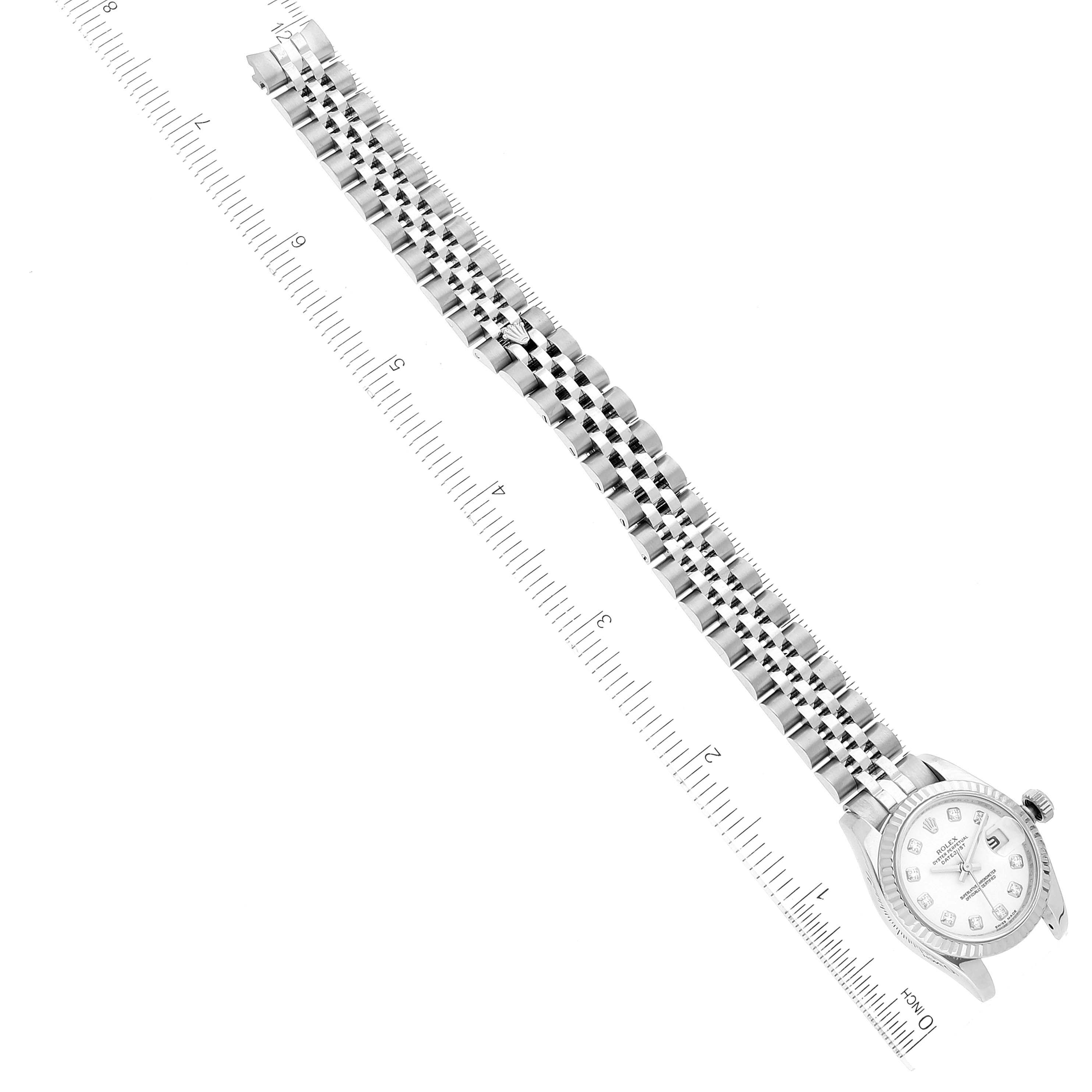 The image shows a Rolex Datejust 179174 Women's Stainless Steel White Dial 179174 Women's Stainless Steel White Dial watch placed diagonally with its bracelet extended and aligned with a ruler.